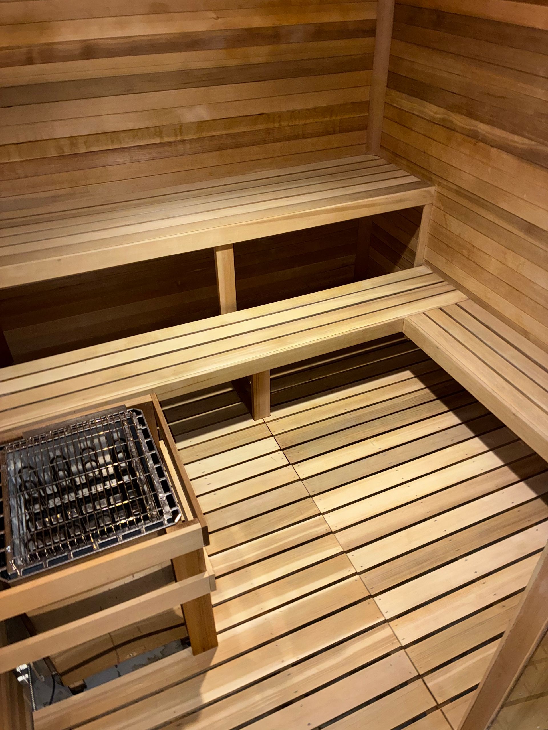 Interior of a wooden sauna with benches and a heating unit.