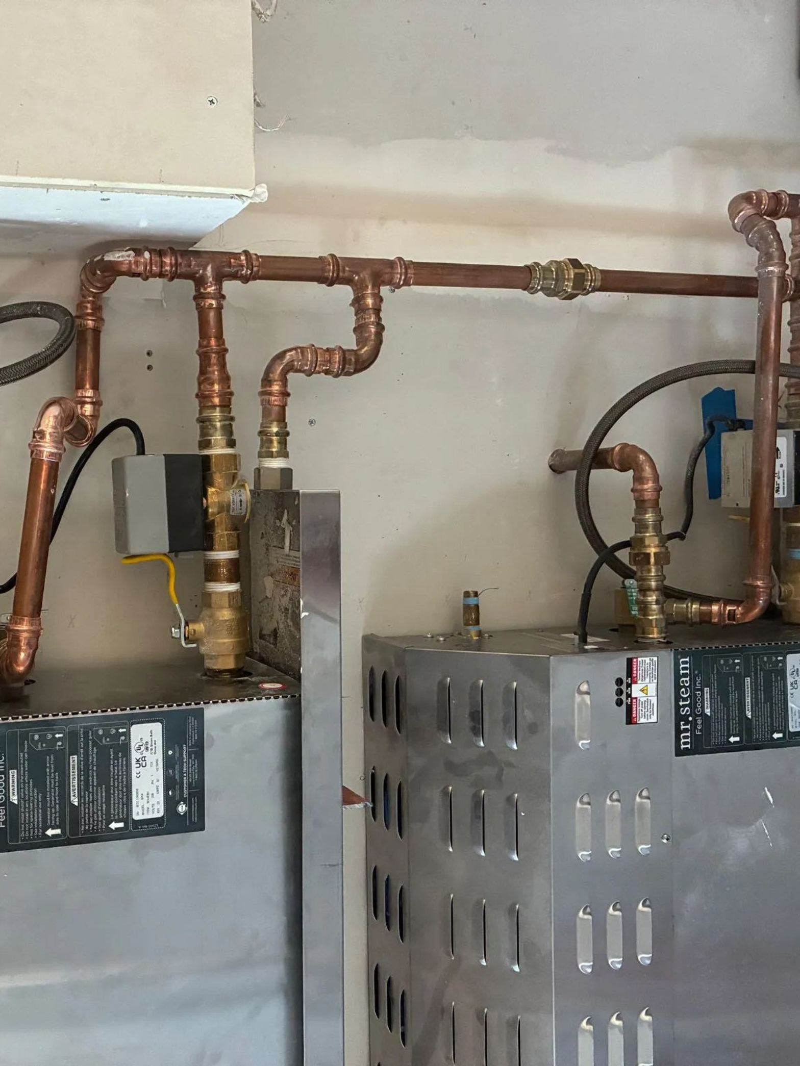 Copper pipes connected to two metal tanks.