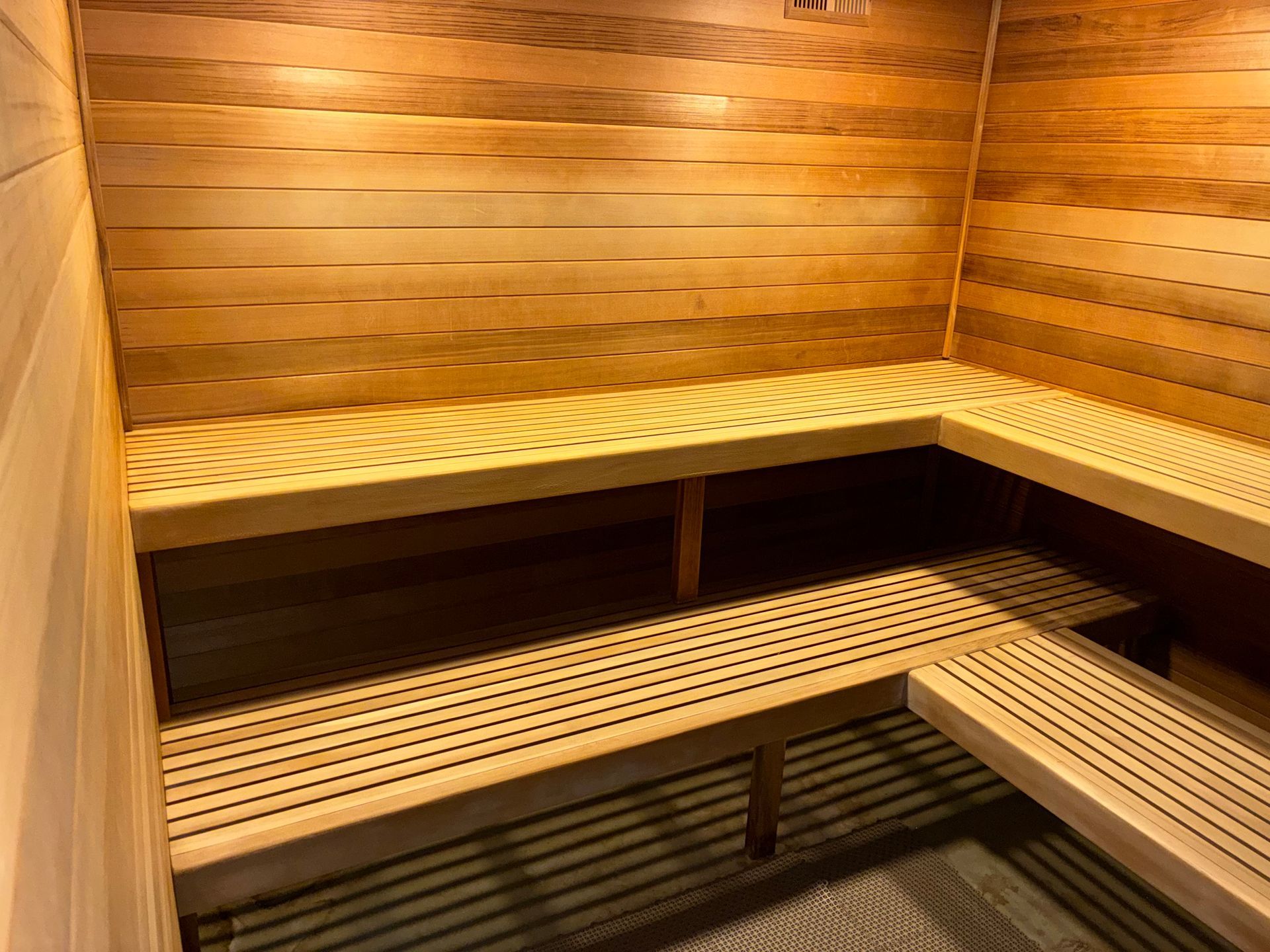 Wooden sauna interior with slatted benches and walls.