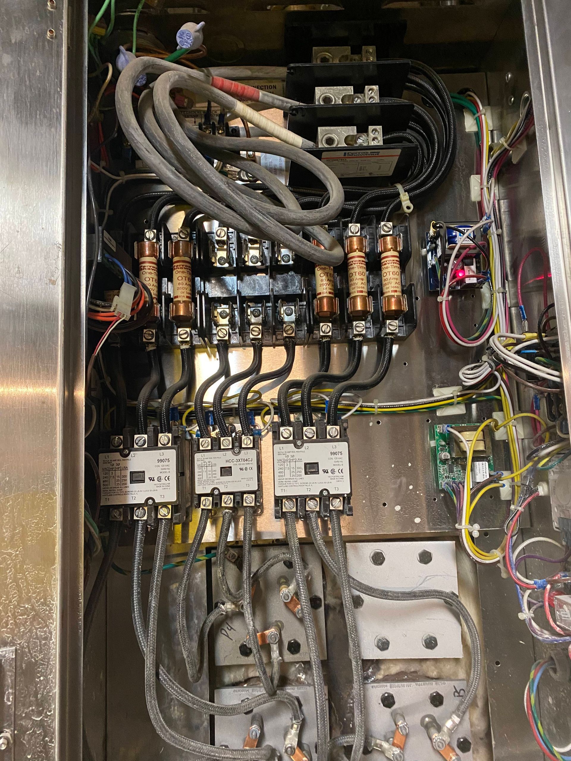 Electrical panel with fuses, contactors, and wiring.