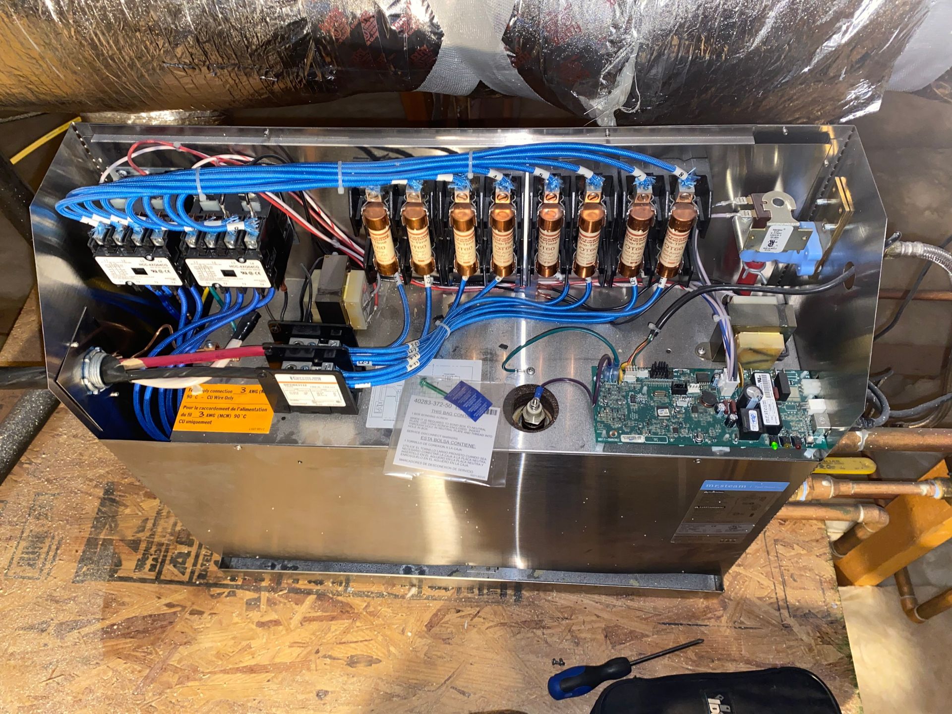 Electrical panel with blue wires, brown relays, and circuit boards.