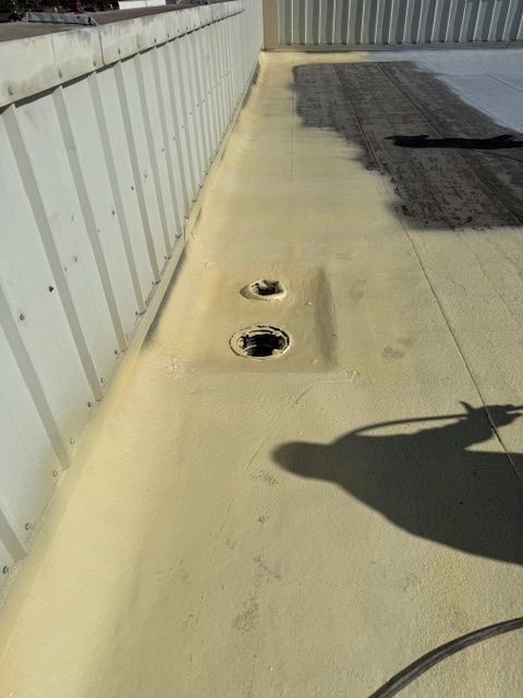 A roof with holes in it and a shadow of a person on it.