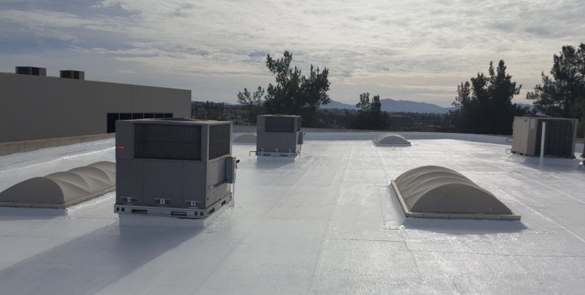 A white roof with a lot of air conditioners on it.
