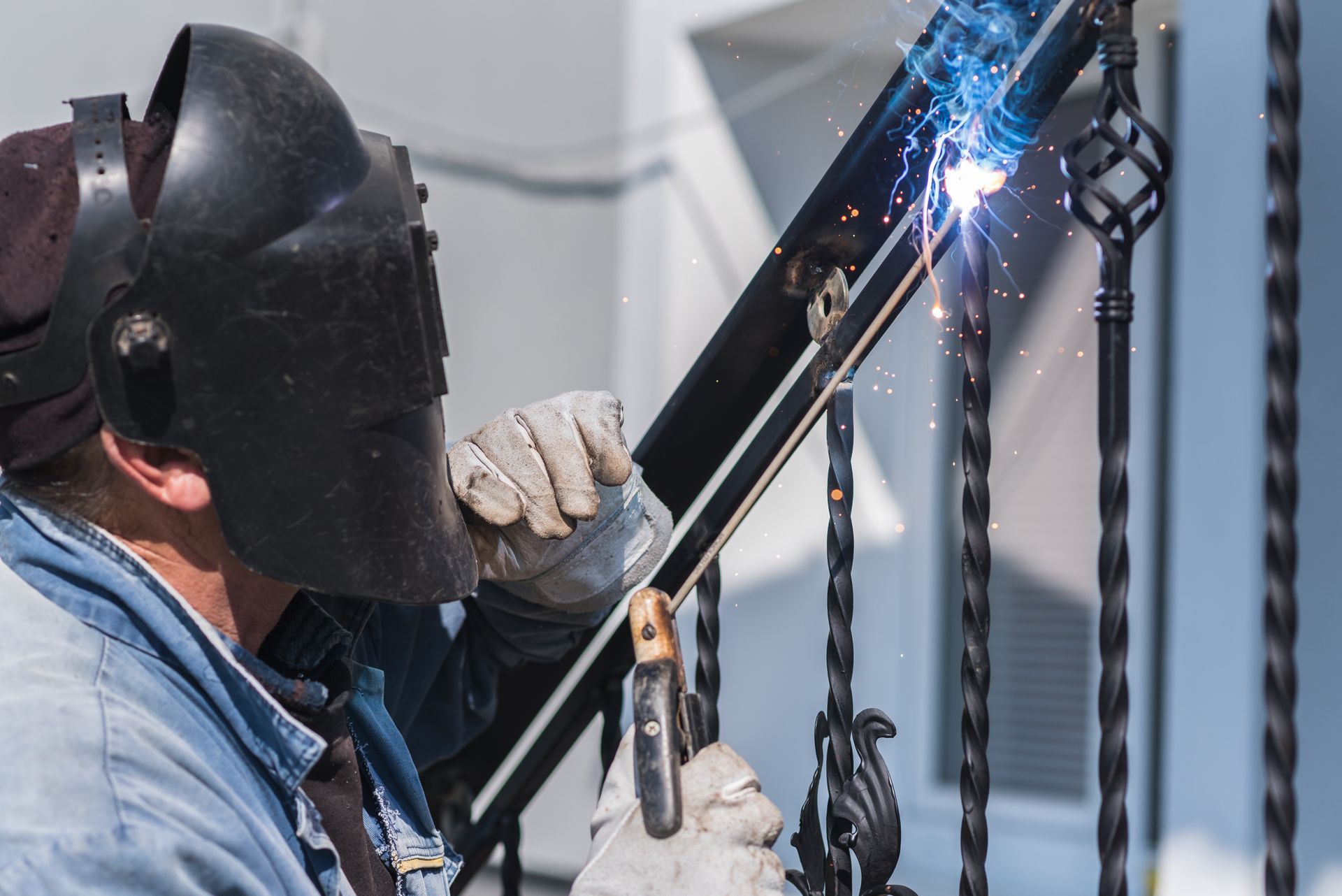 a man wearing a welding mask is welding a handrail