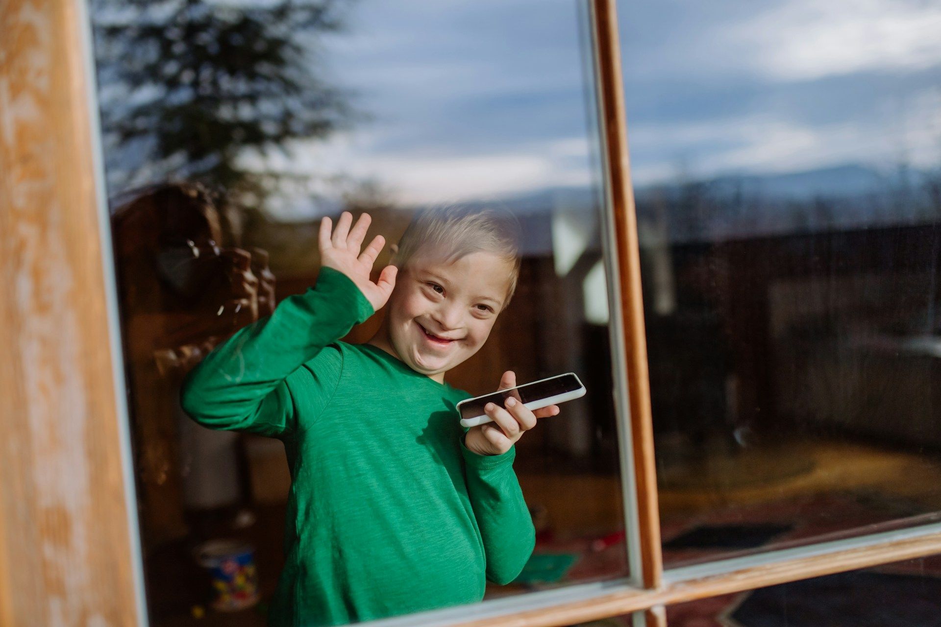 child waving from the window