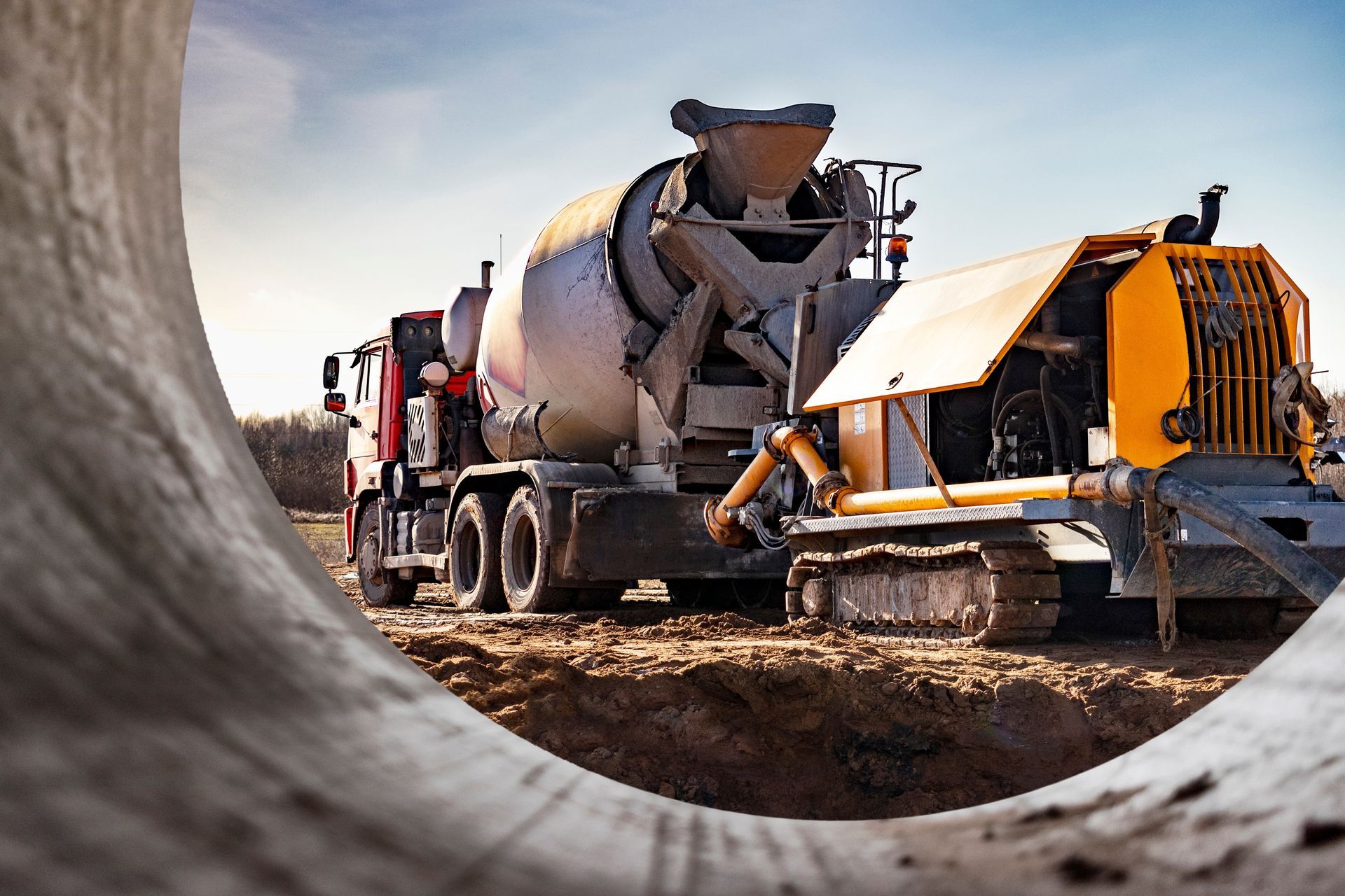 Cement Truck Pouring Concrete Into a Construction Machine in a Trench — Salisbury Concrete Contractors In Ocean Shores, NSW