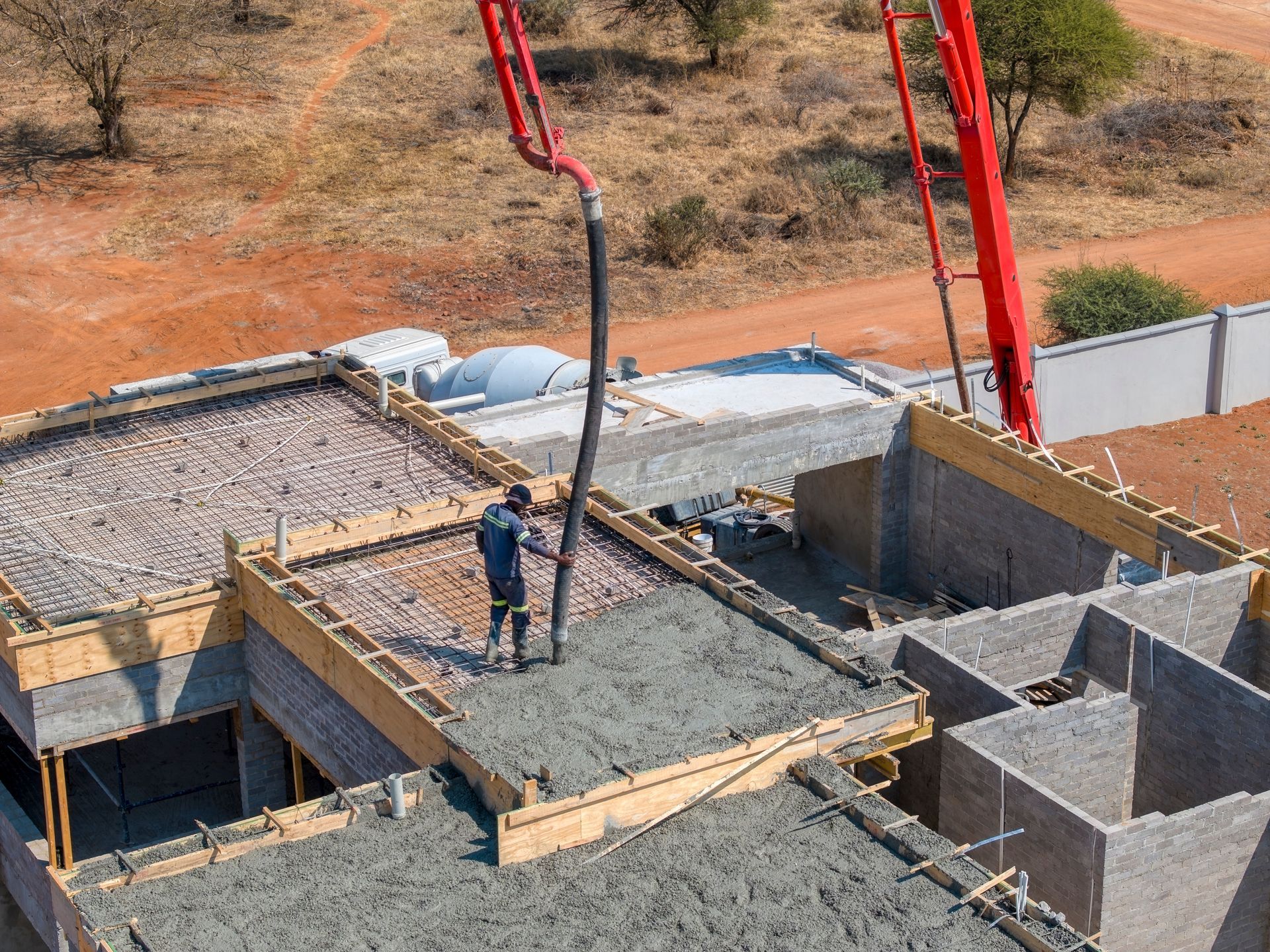 Construction Worker Pouring Concrete Onto a Roof With a Pump Truck — Salisbury Concrete Contractors In Ocean Shores, NSW