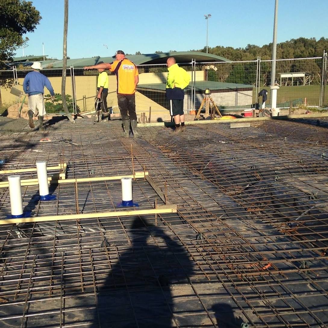 Construction Site With Workers Laying Concrete; Grid of Rebar — Salisbury Concrete Contractors In Ocean Shores, NSW
