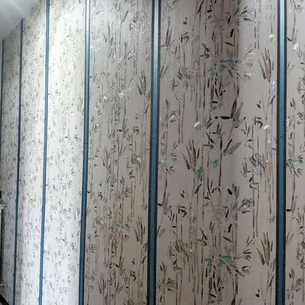 Parete con carta da parati con motivo a bambù, separata da strisce verticali color verde acqua.