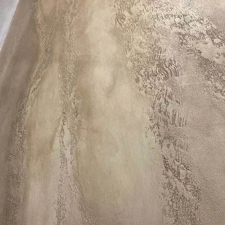 Parete beige testurizzata con striature e motivi verticali.