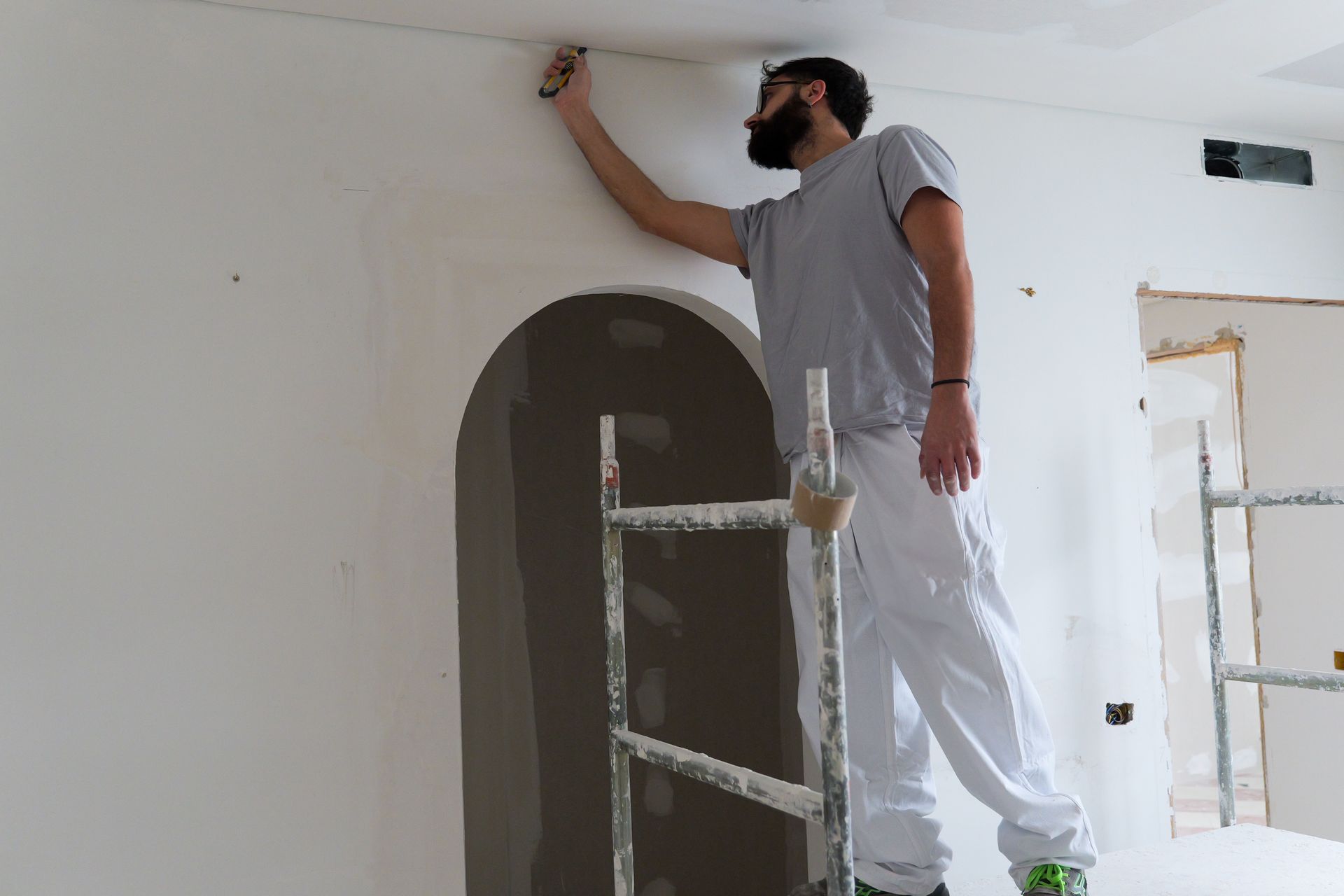 Camera da letto con letto, testiera scura, biancheria morbida, due lampade da comodino e una luna dipinta sulla parete.