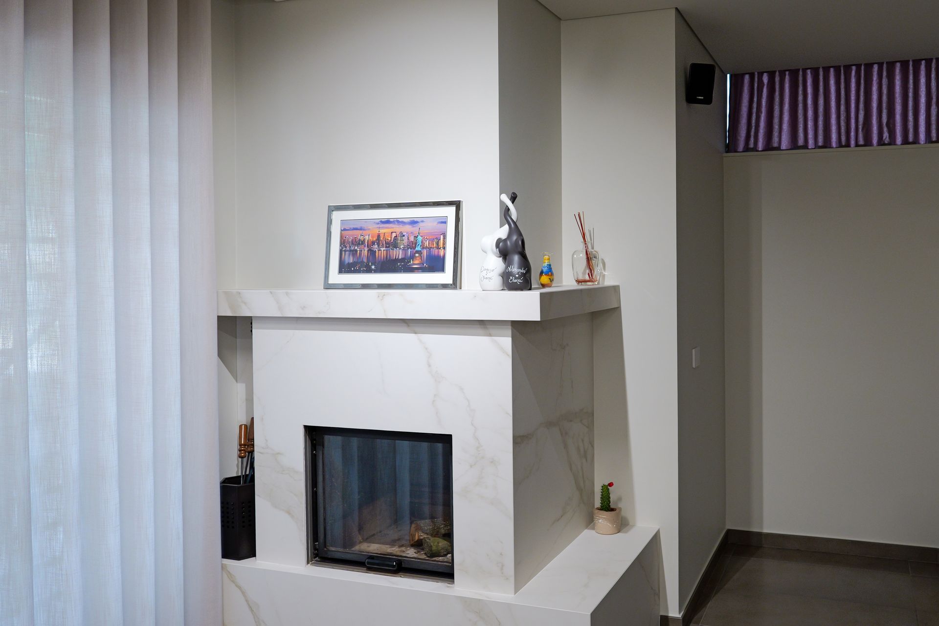 Ampio soggiorno con ampie finestre che si affacciano sul paesaggio. Dispone di divano, tappeto, mobili in legno e una grande pianta da interno.