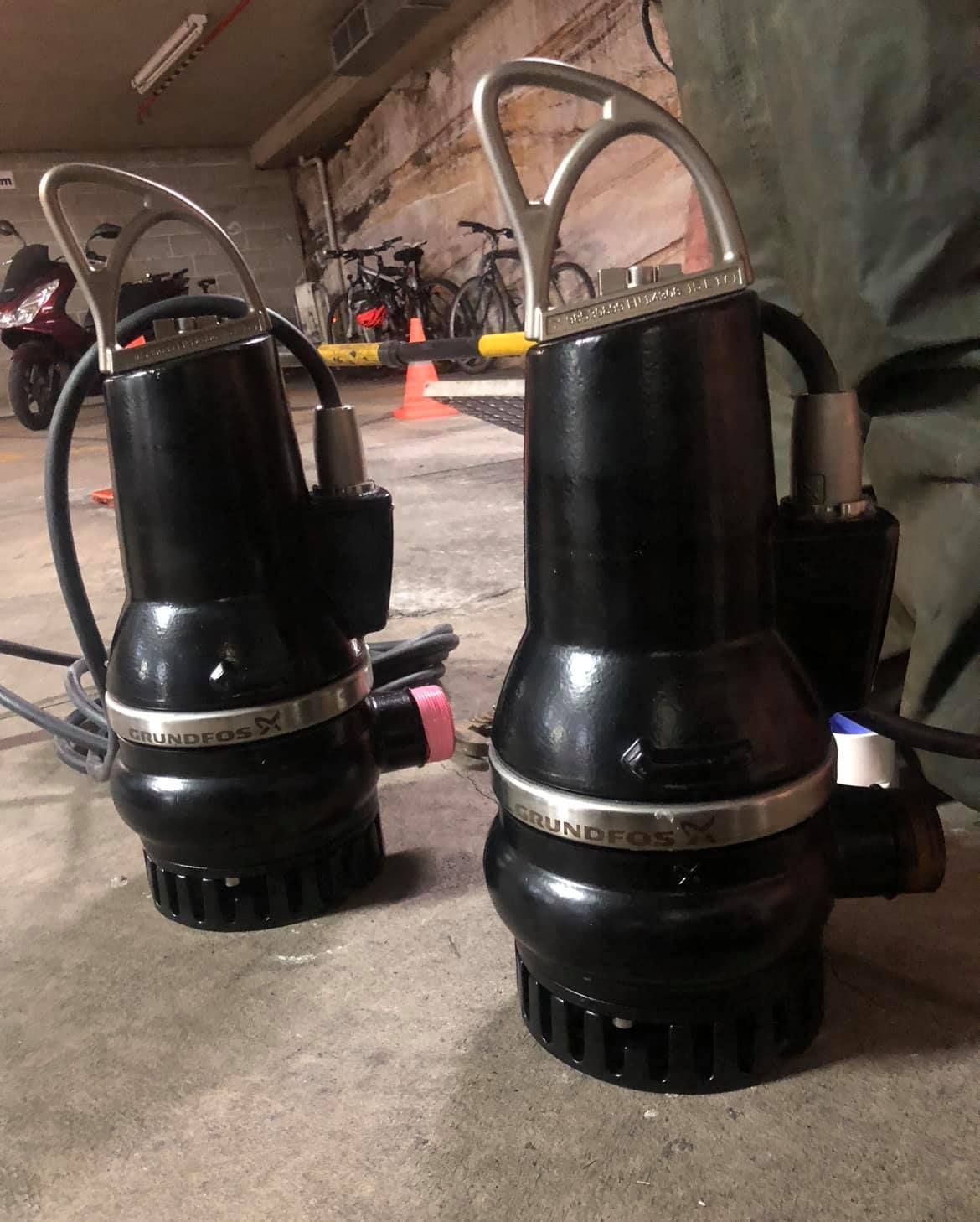 A black pump is sitting on top of a wooden table.