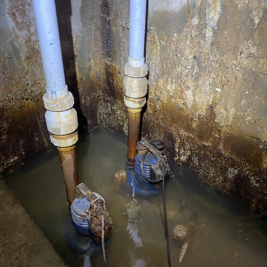 Two technicians performing a submersible pump replacement in a confined space with tripod setup, gas