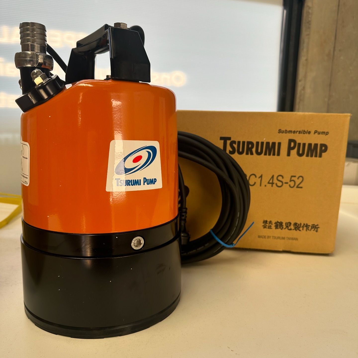 A box for a tsurumi pump sits on a table