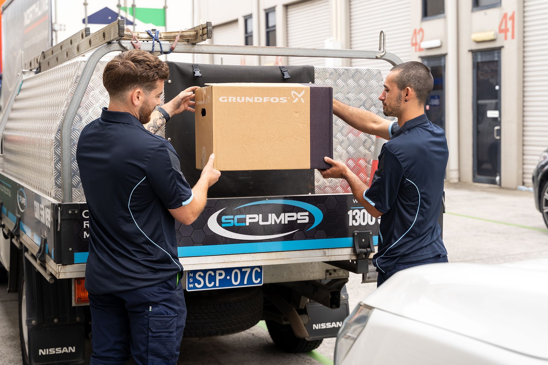SC Pumps staff holding an unopened Grundfos box.