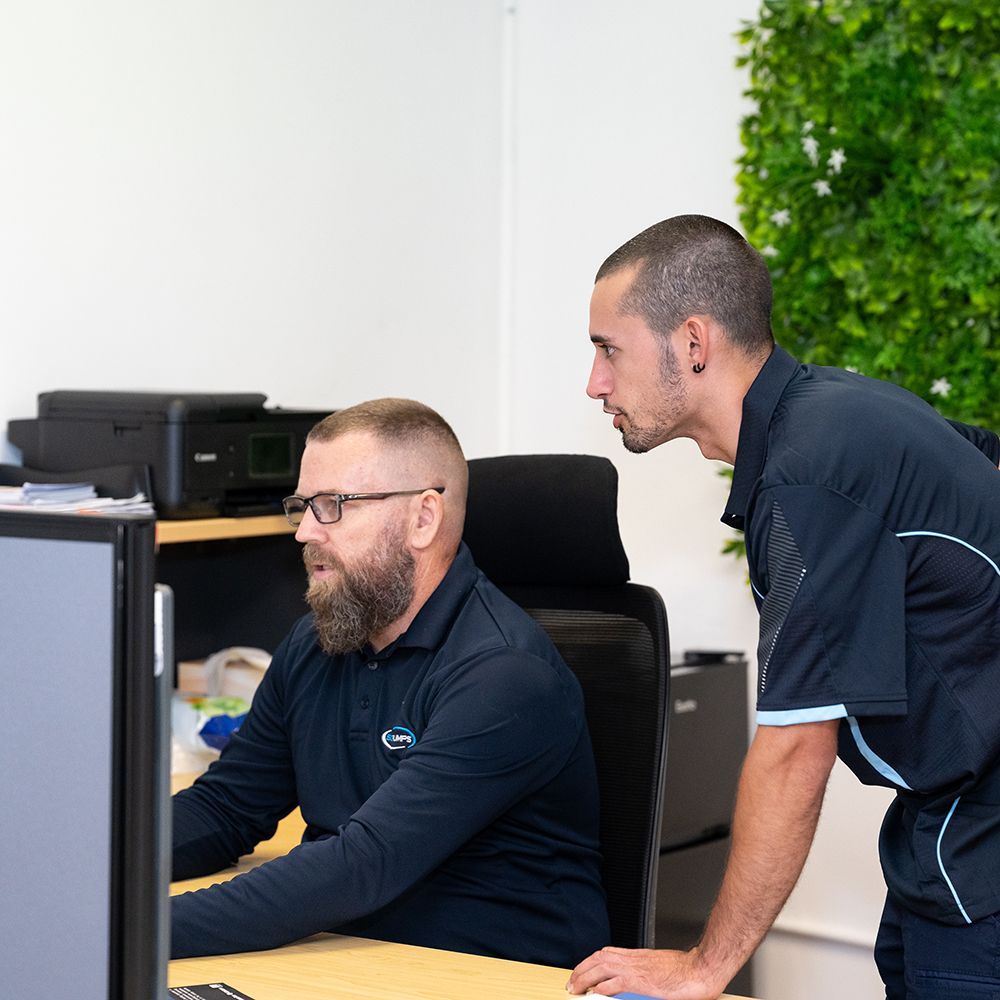 two men looking at a computer