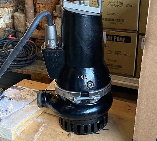 A black pump is sitting on top of a wooden table.