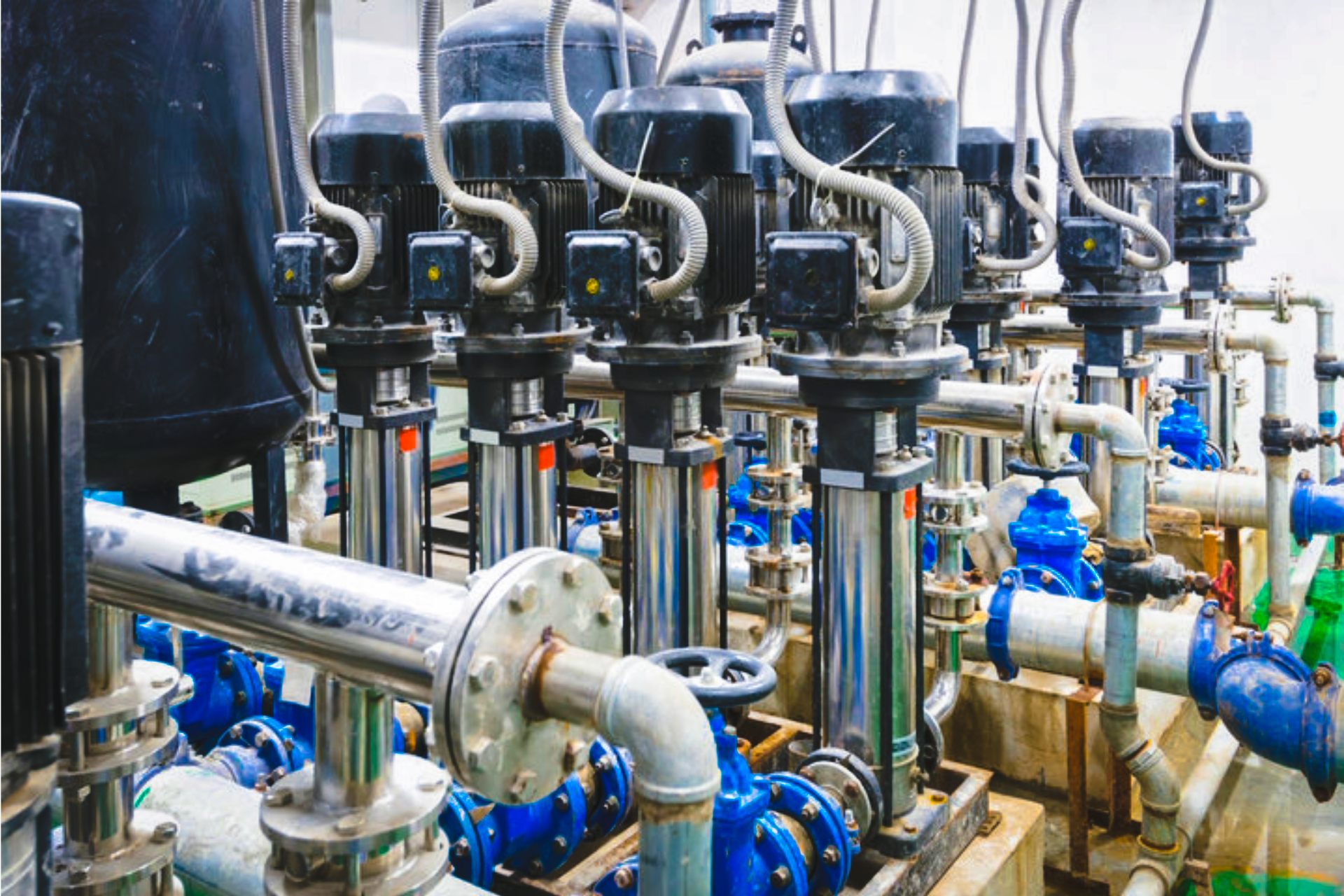 Industrial piping and valves with blue fittings in a factory setting