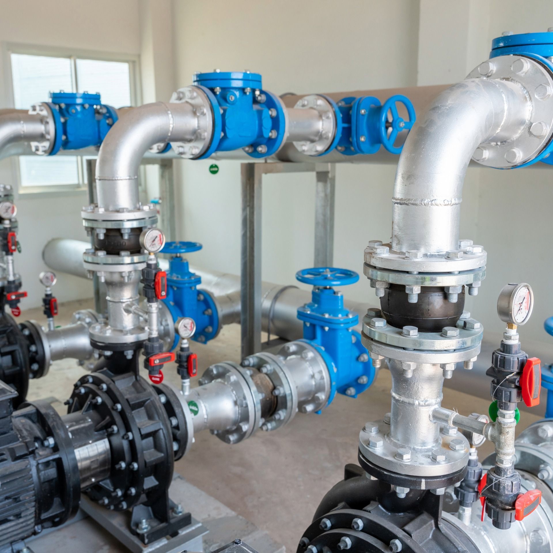 Industrial water pipes and valves with blue and silver components.