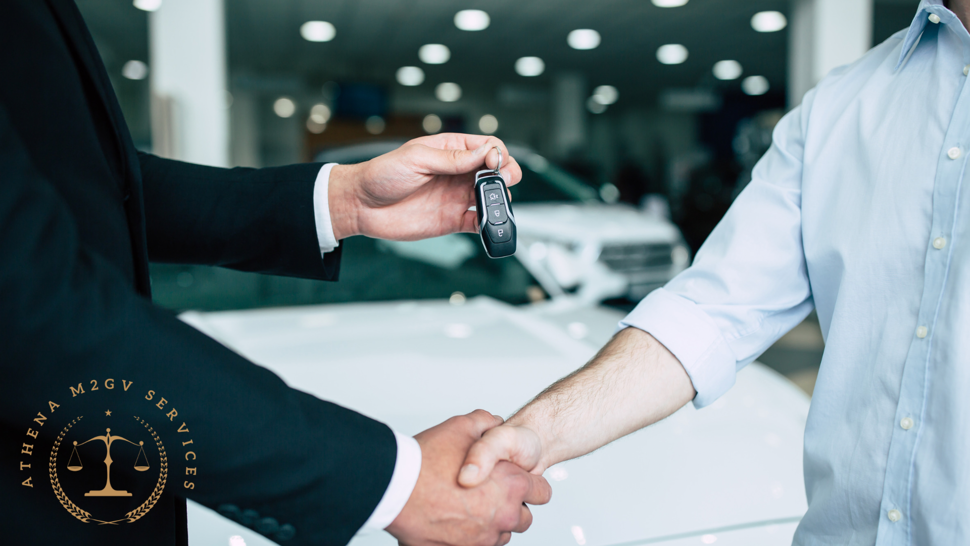Man in suit handing car keys to another man shaking hands in a dealership.