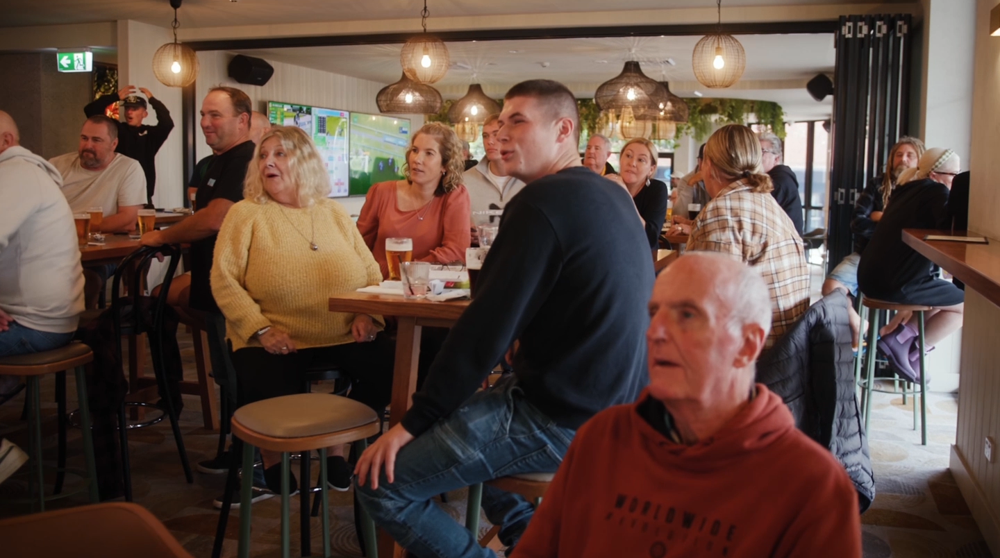 A group of people are sitting at tables in a venue.