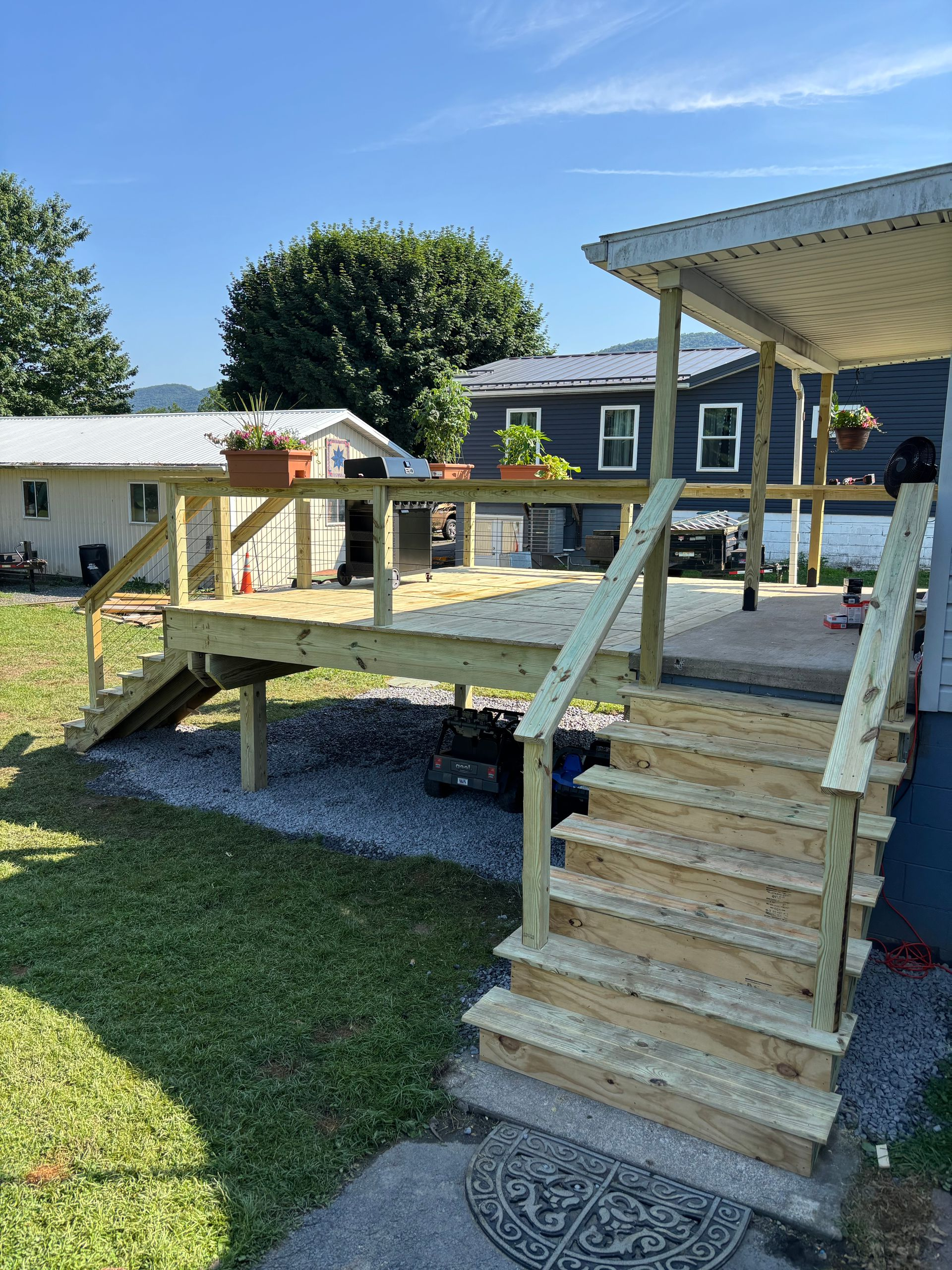 Cozy living room with brown sofa, rug, and fireplace. Stairs lead up. Dark green and white walls.