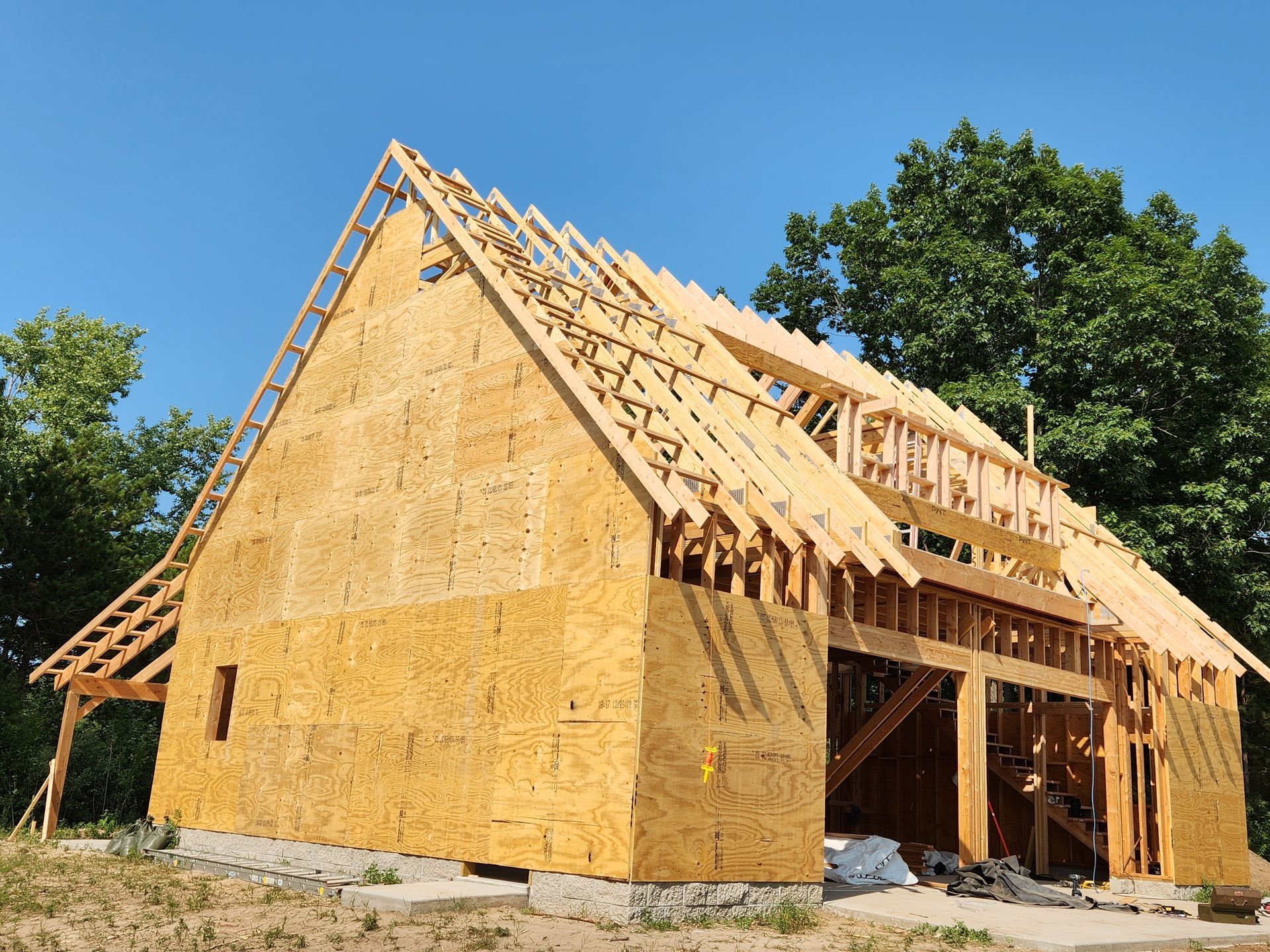 A wooden house under construction with a blue sky in the background