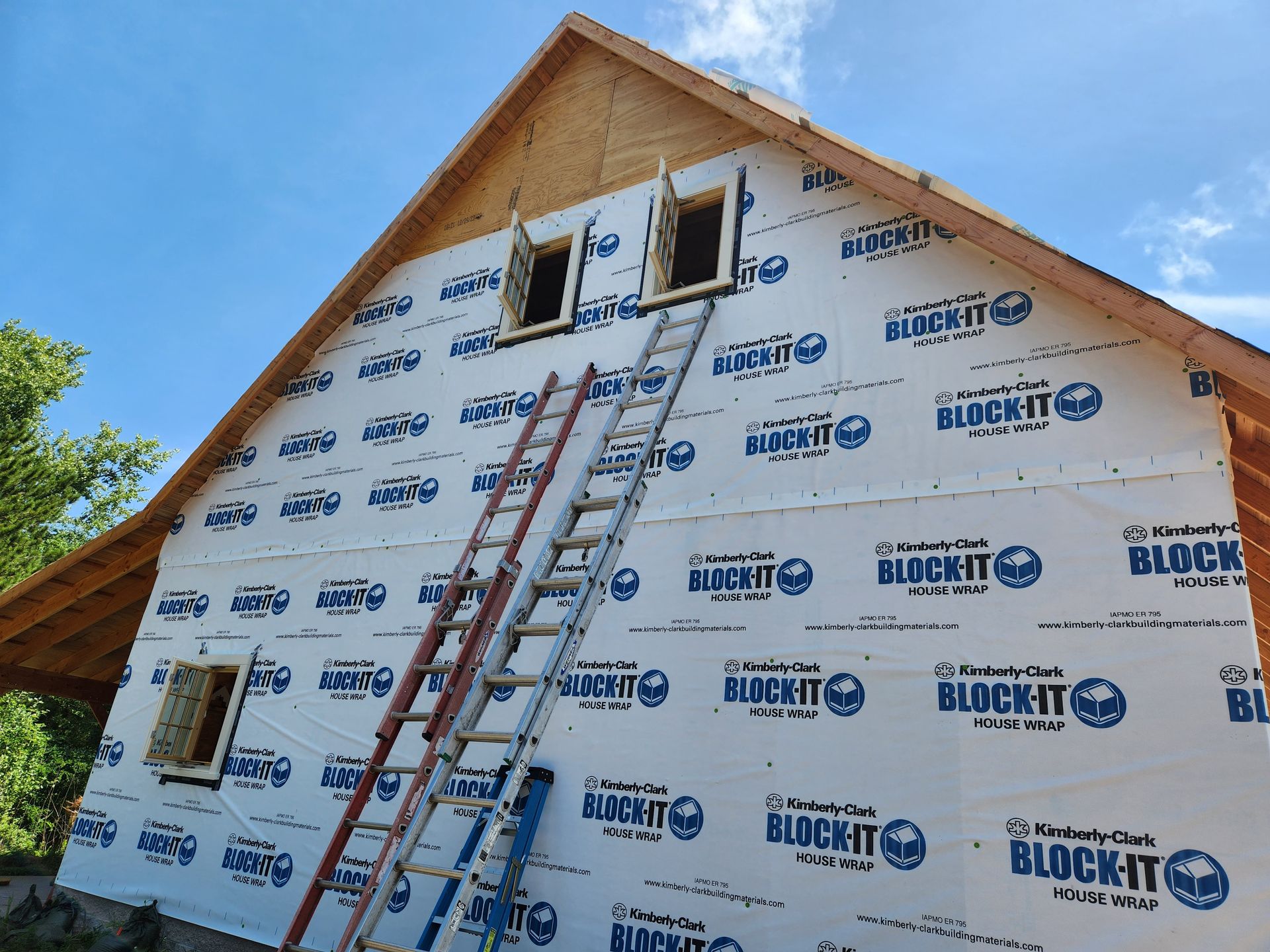 A ladder is hanging from the side of a building covered in block it