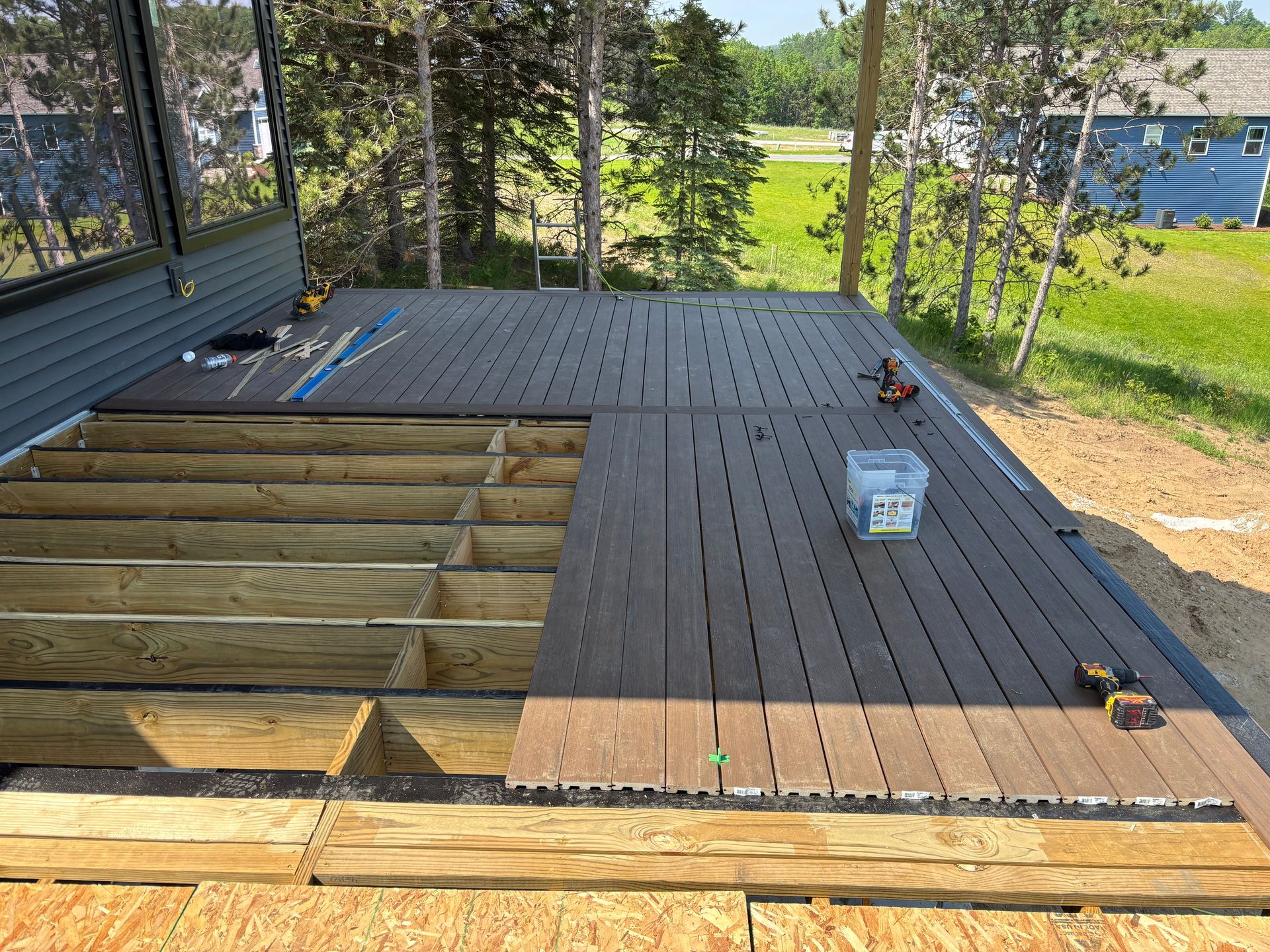 A wooden deck is being built in the backyard of a house.