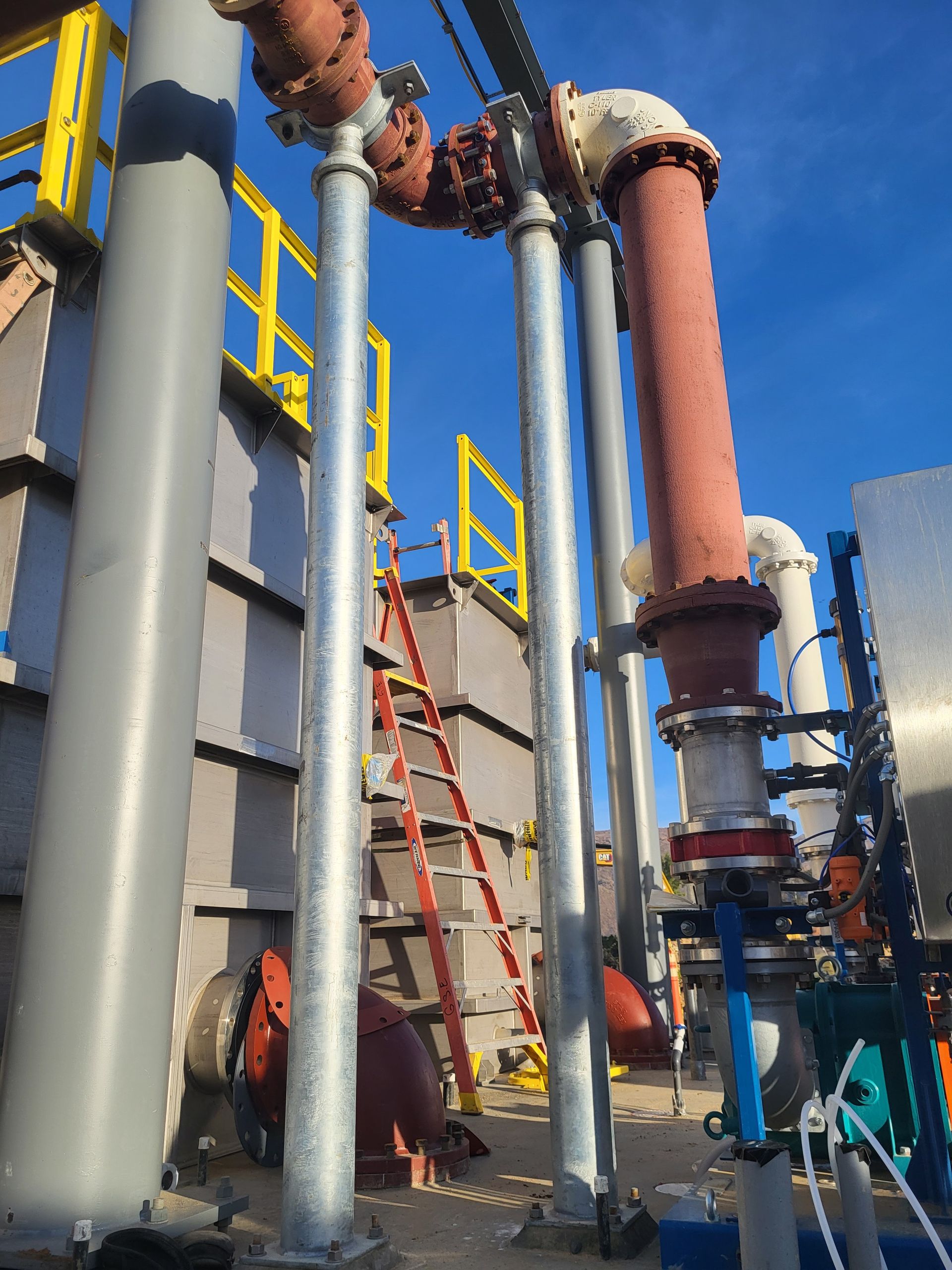  5D Company llc a bunch of pipes and a ladder in a factory