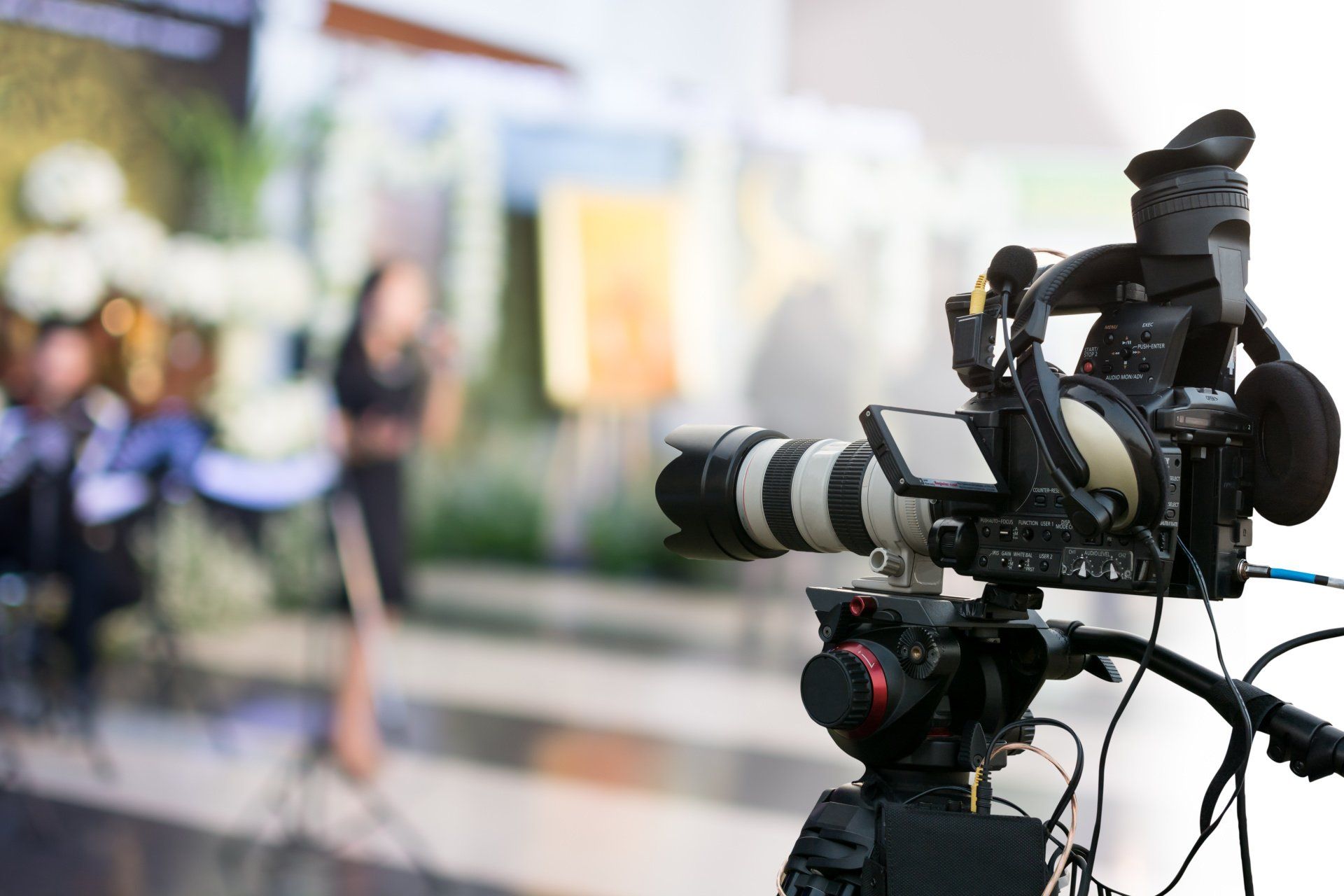 Une caméra vidéo enregistre une femme debout devant un microphone.