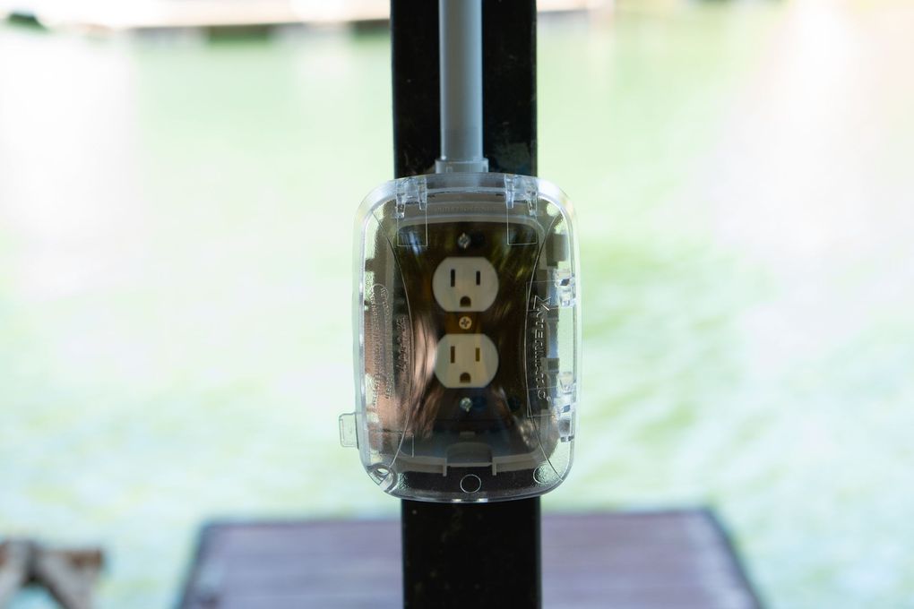 A close up of an electrical outlet on a pole.