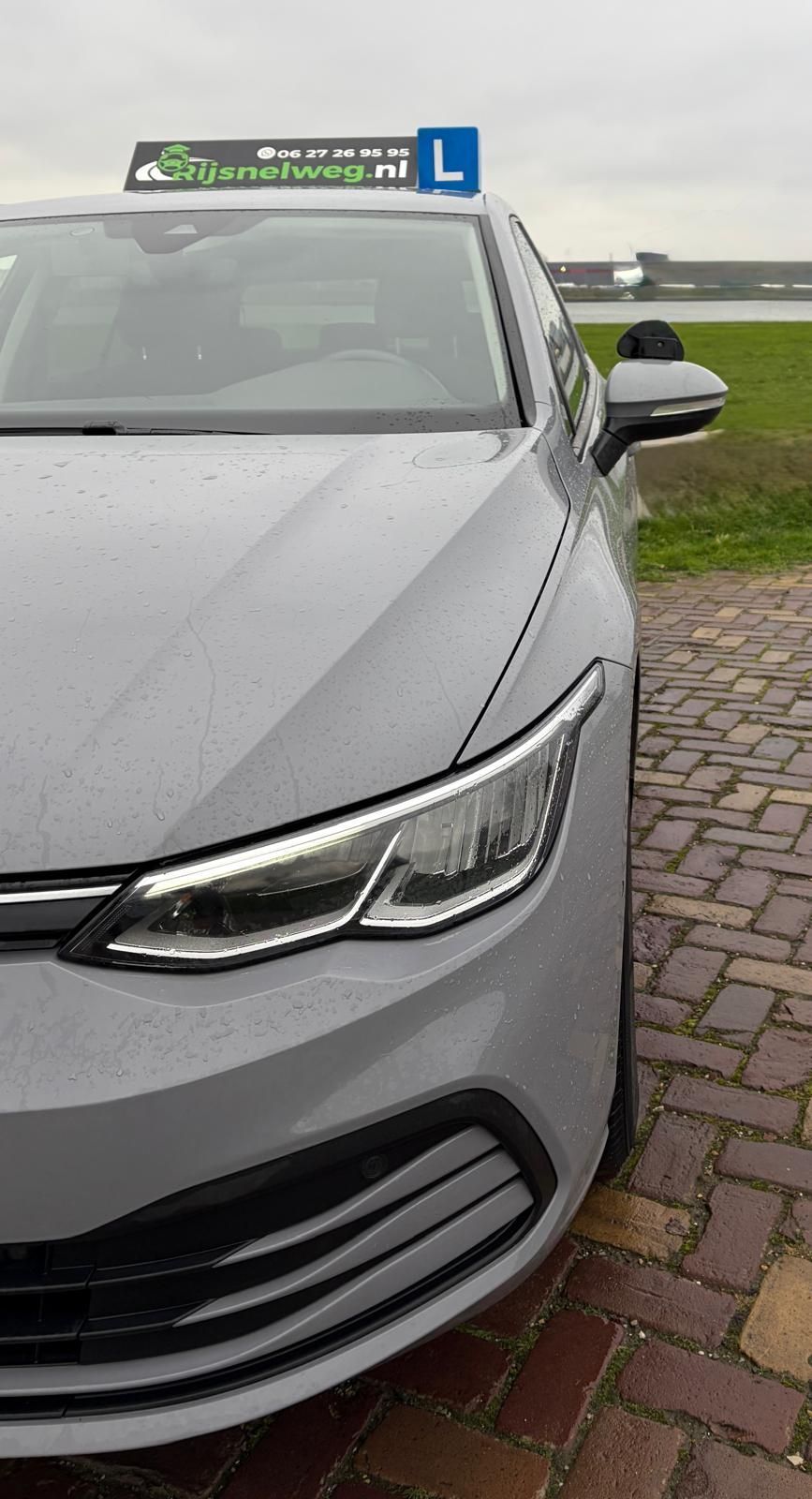 Zwart auto-interieur met dashboard, stuurwiel, infotainmentscherm en ventilatieroosters.