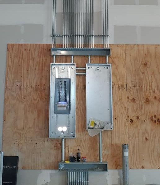A electrical box is hanging on a wooden wall.