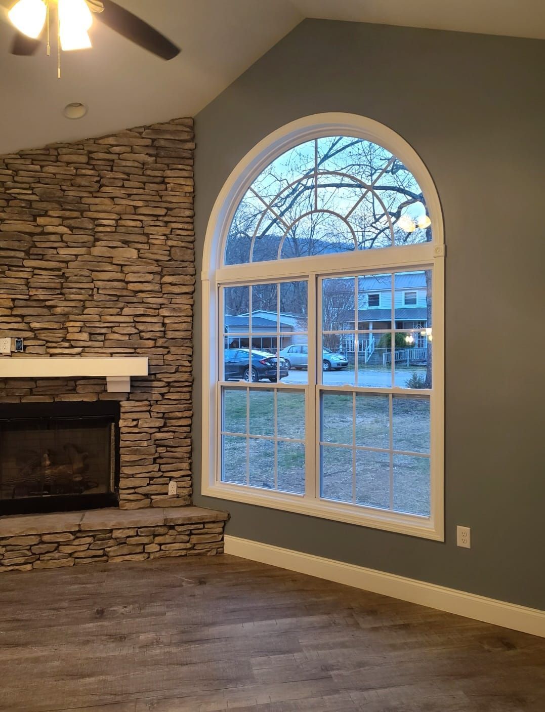 A living room with a fireplace and a large window