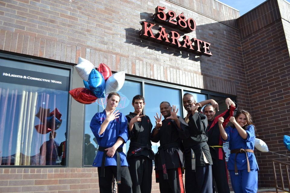A group of people standing in front of a karate school