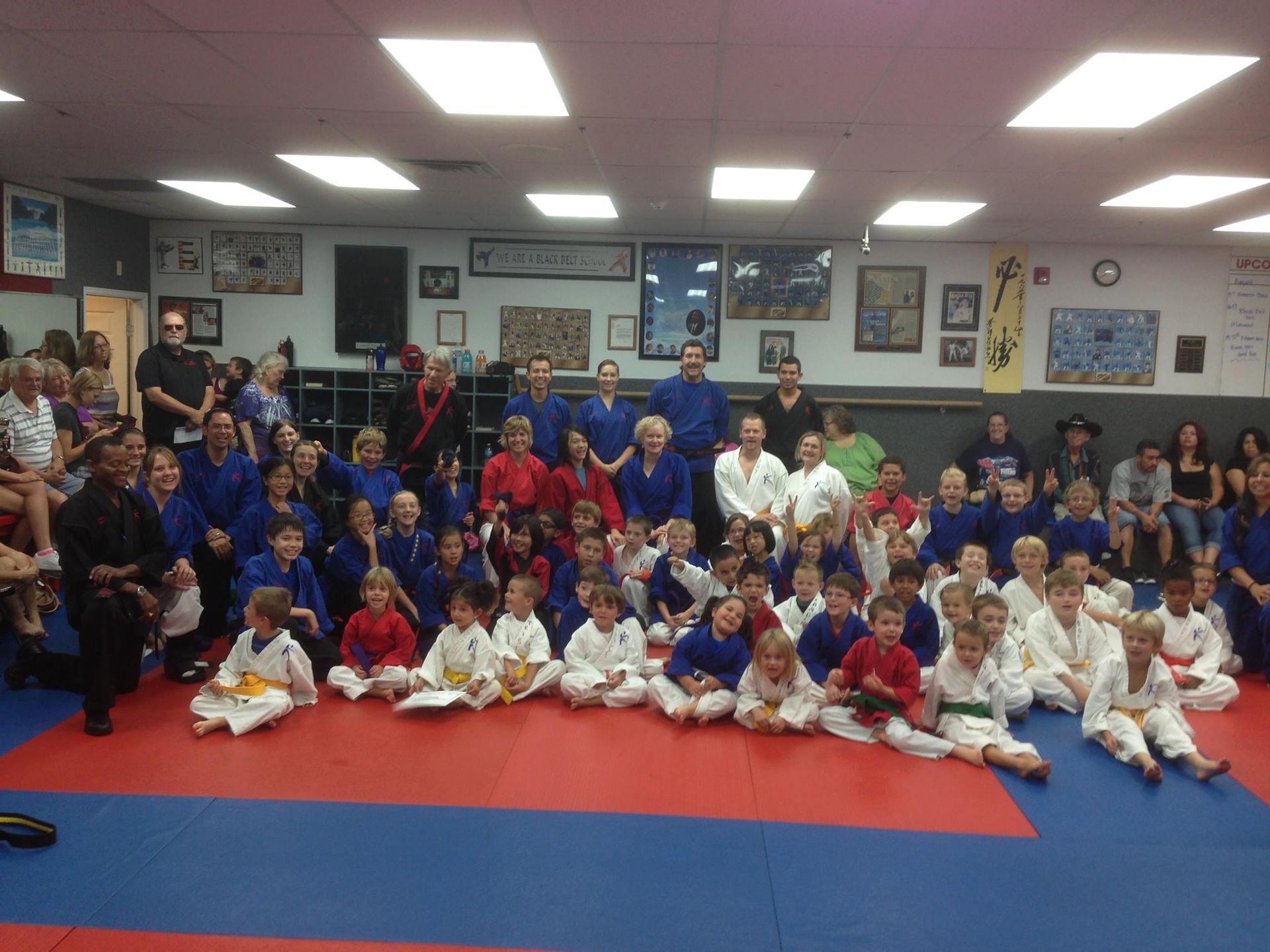 A group of people are posing for a picture in a gym.
