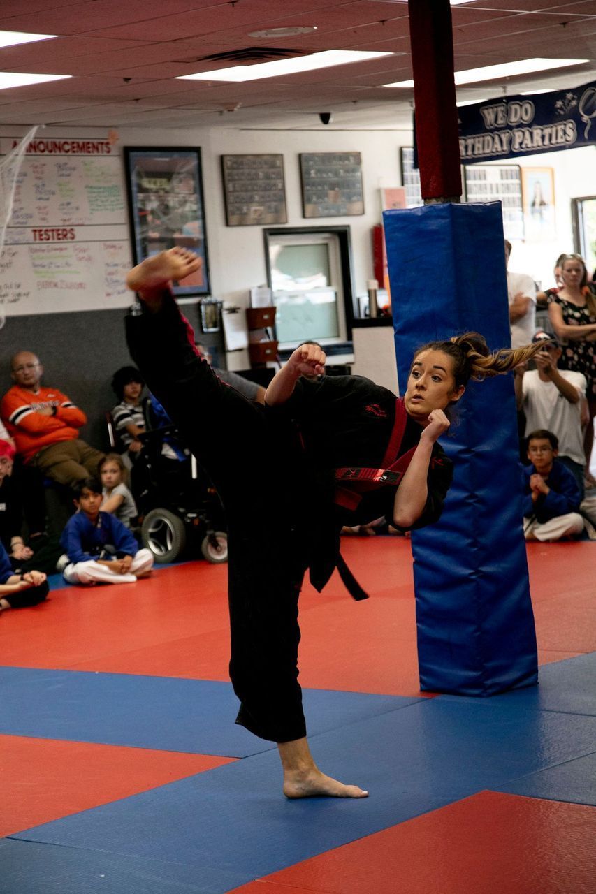 A girl is doing a kick in a karate class