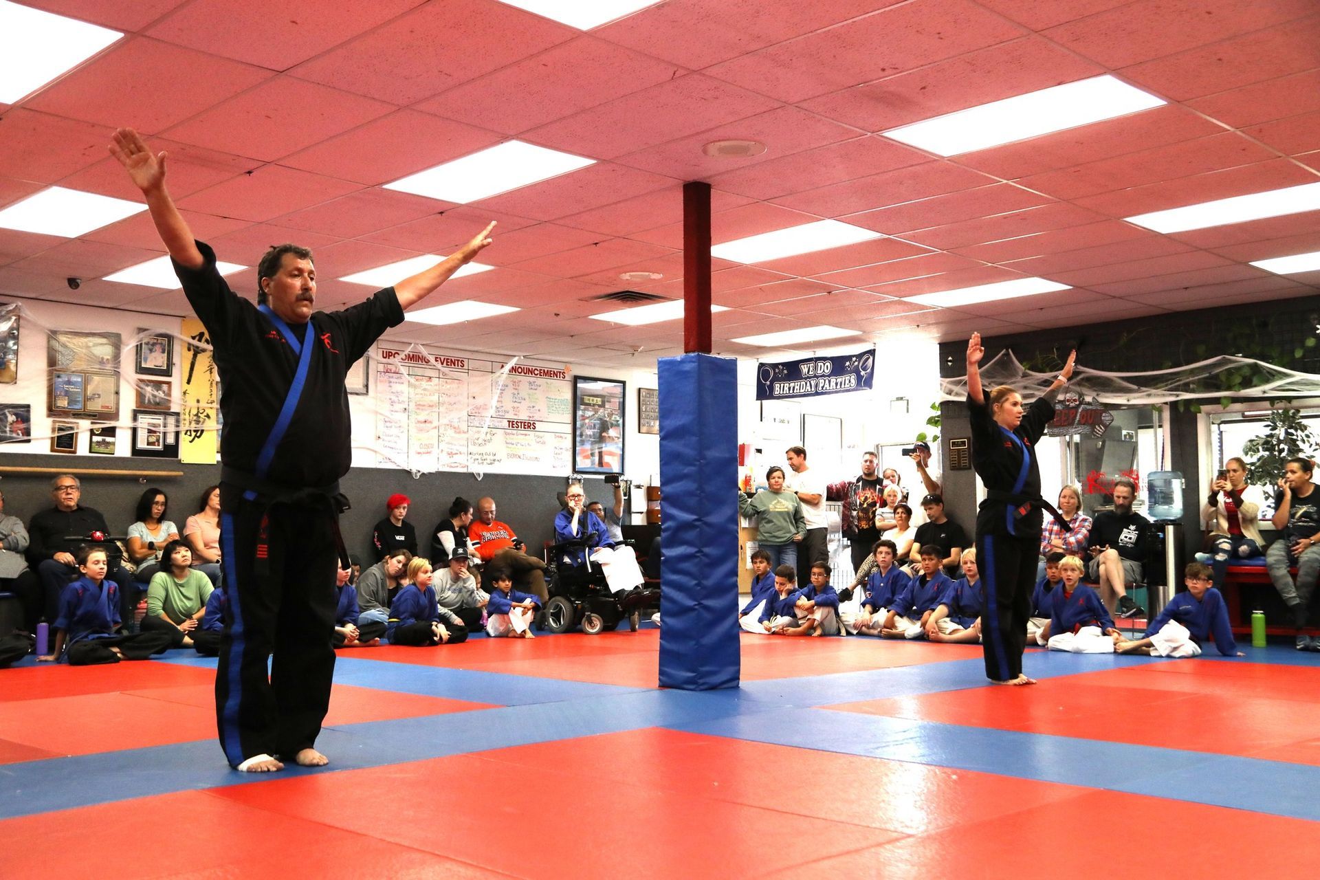 A man and a woman are practicing martial arts in a gym