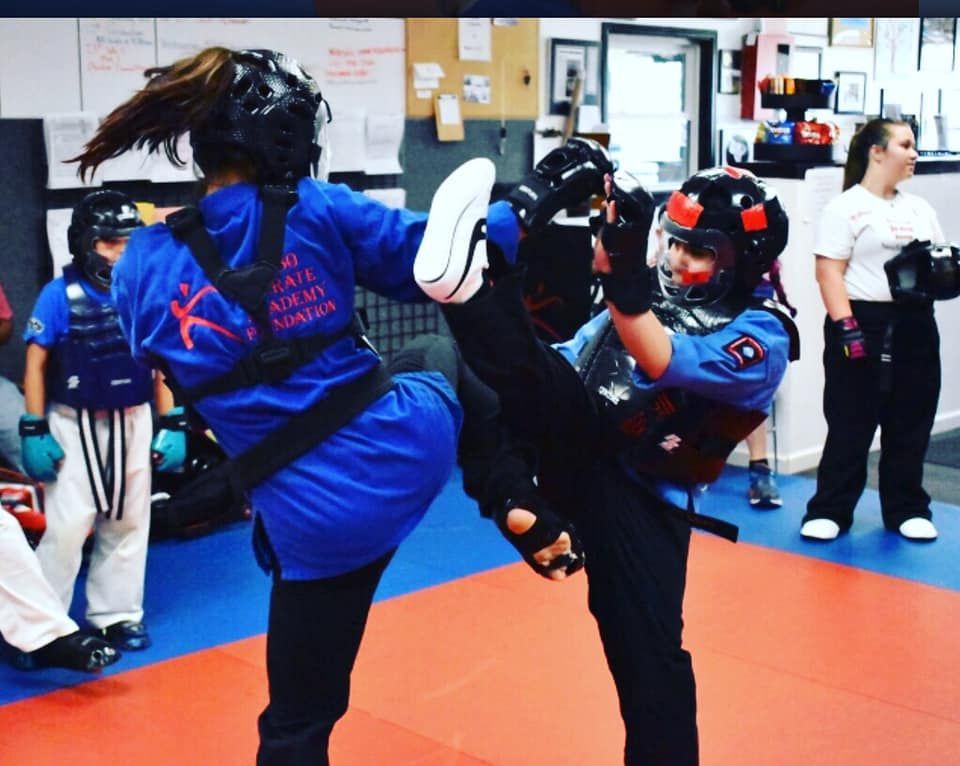 A person wearing a blue shirt that says karate on it