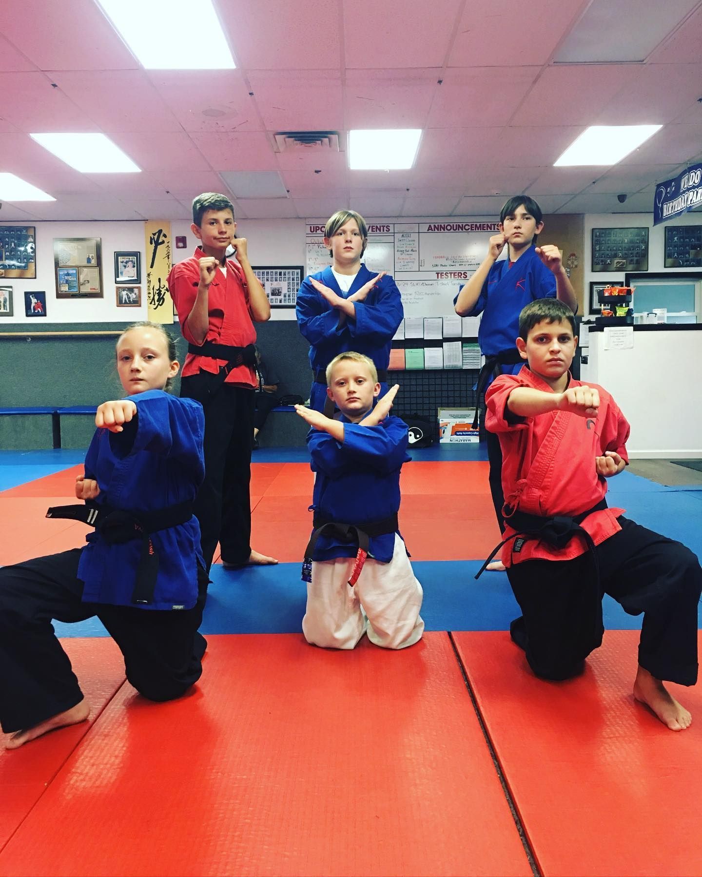 A group of young boys are practicing martial arts in a gym.