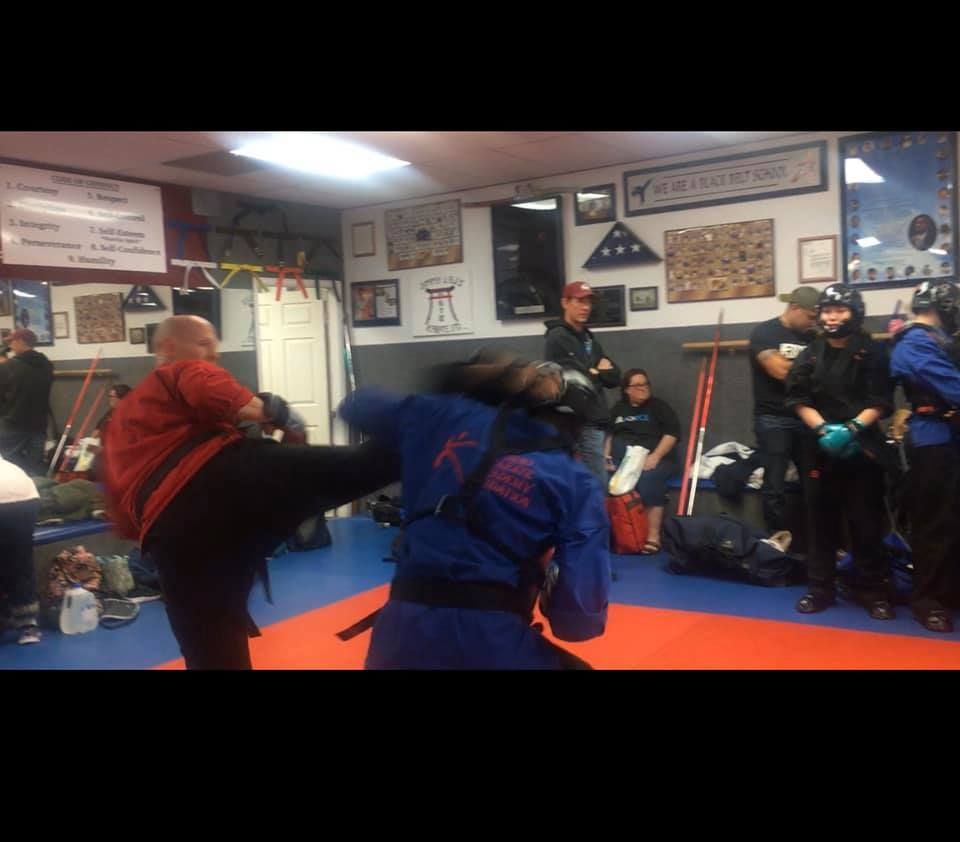 A group of people are practicing martial arts in a gym