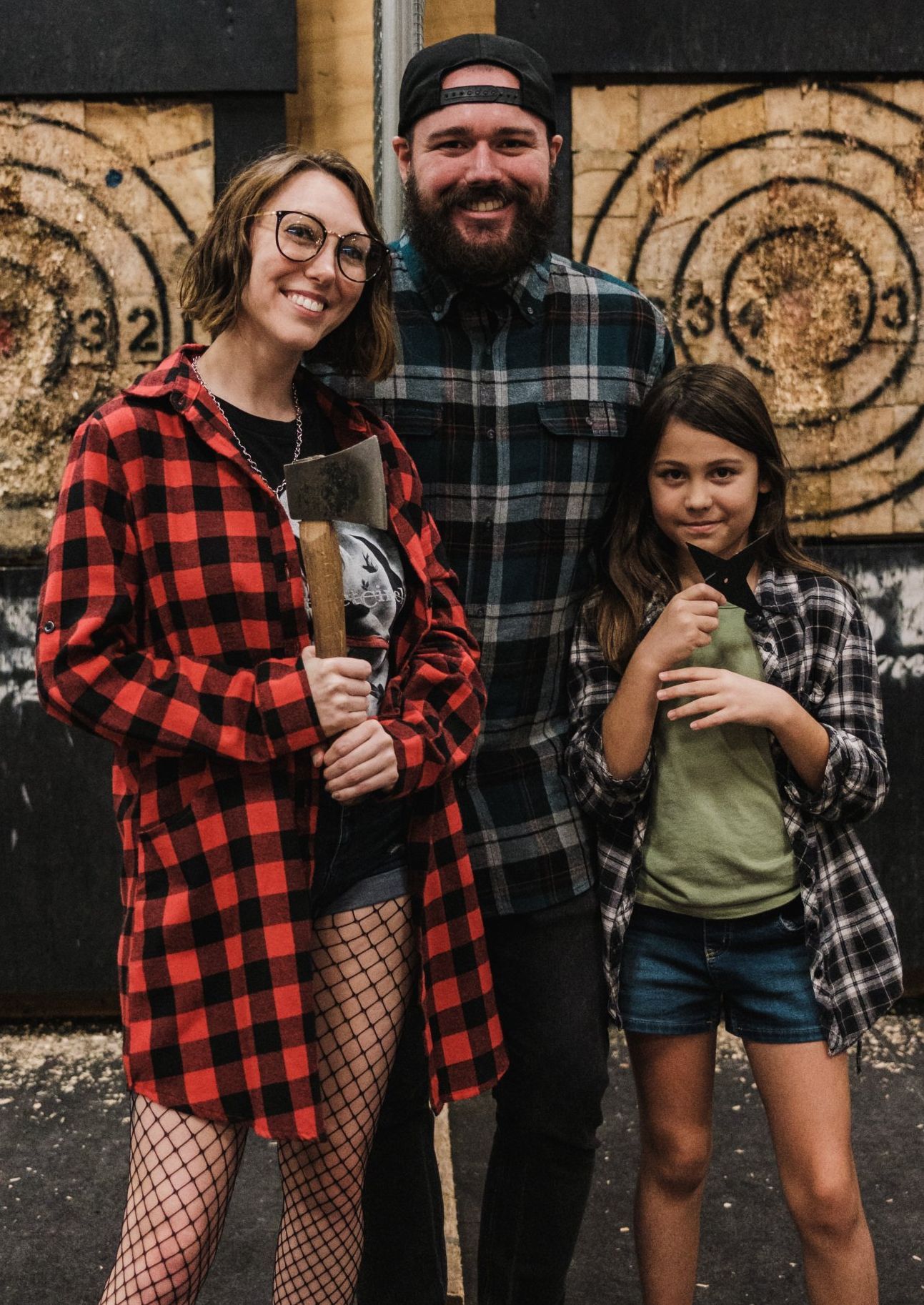 A man , woman and child are posing for a picture in front of a target.