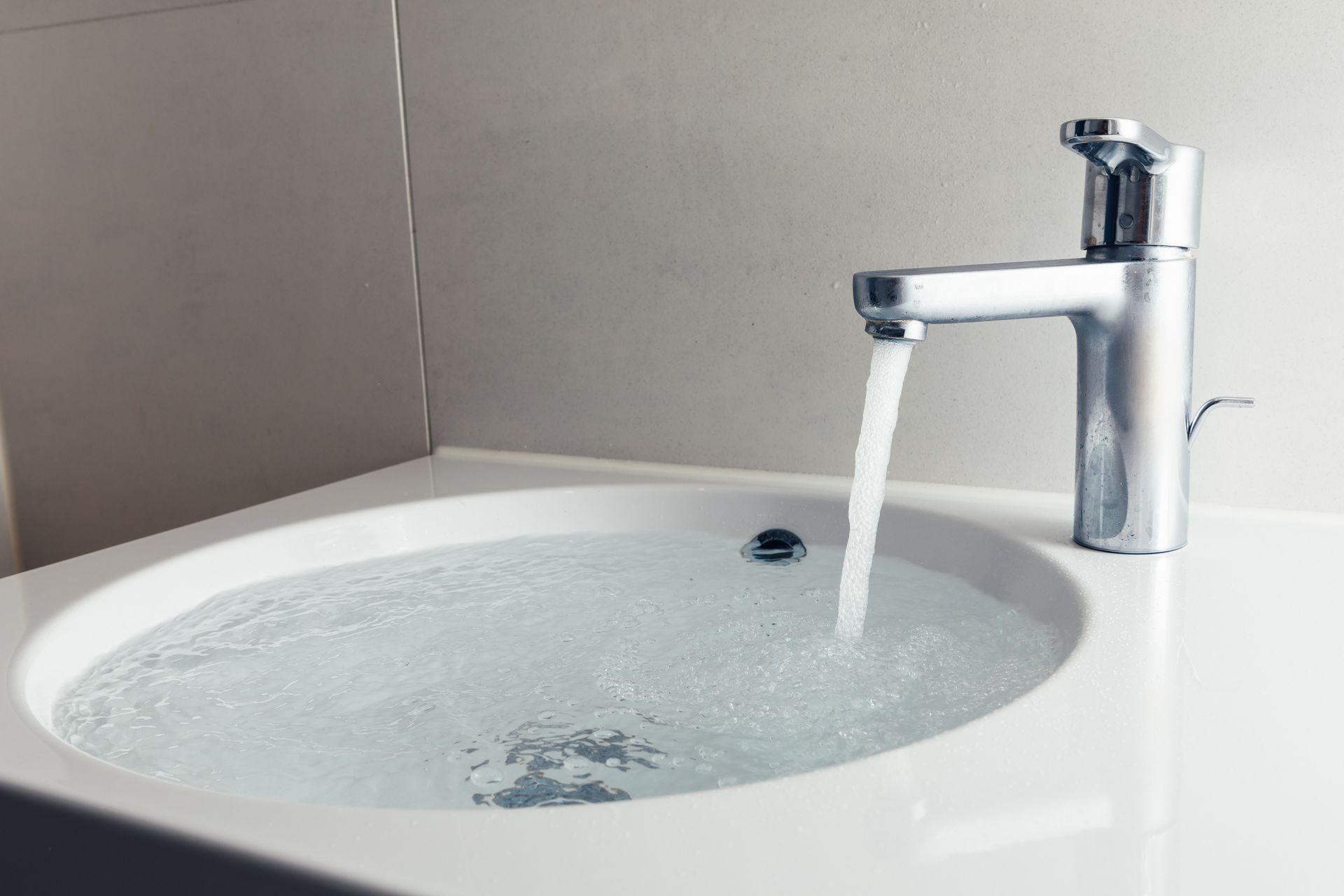 faucet on with running water filling up a sink