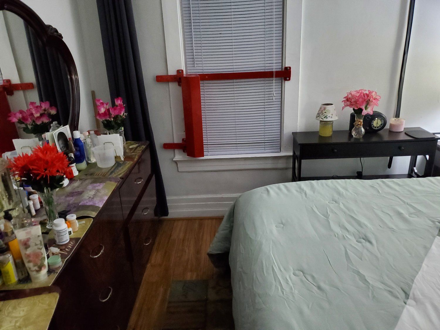 A bedroom with a bed a dresser and a mirror