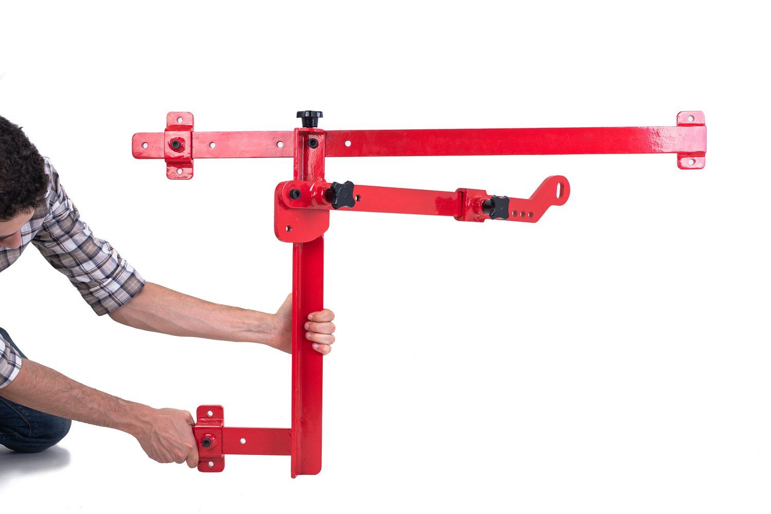 A man is kneeling down and holding a red object.