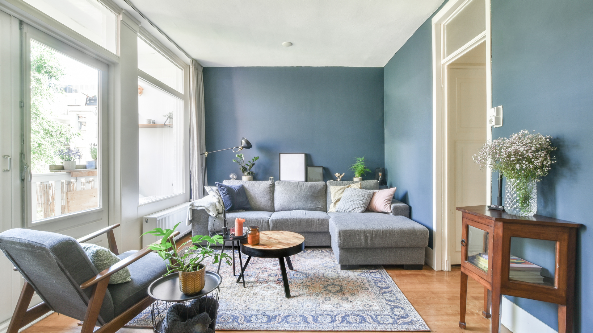 A living room with a couch , chair , table and blue walls.