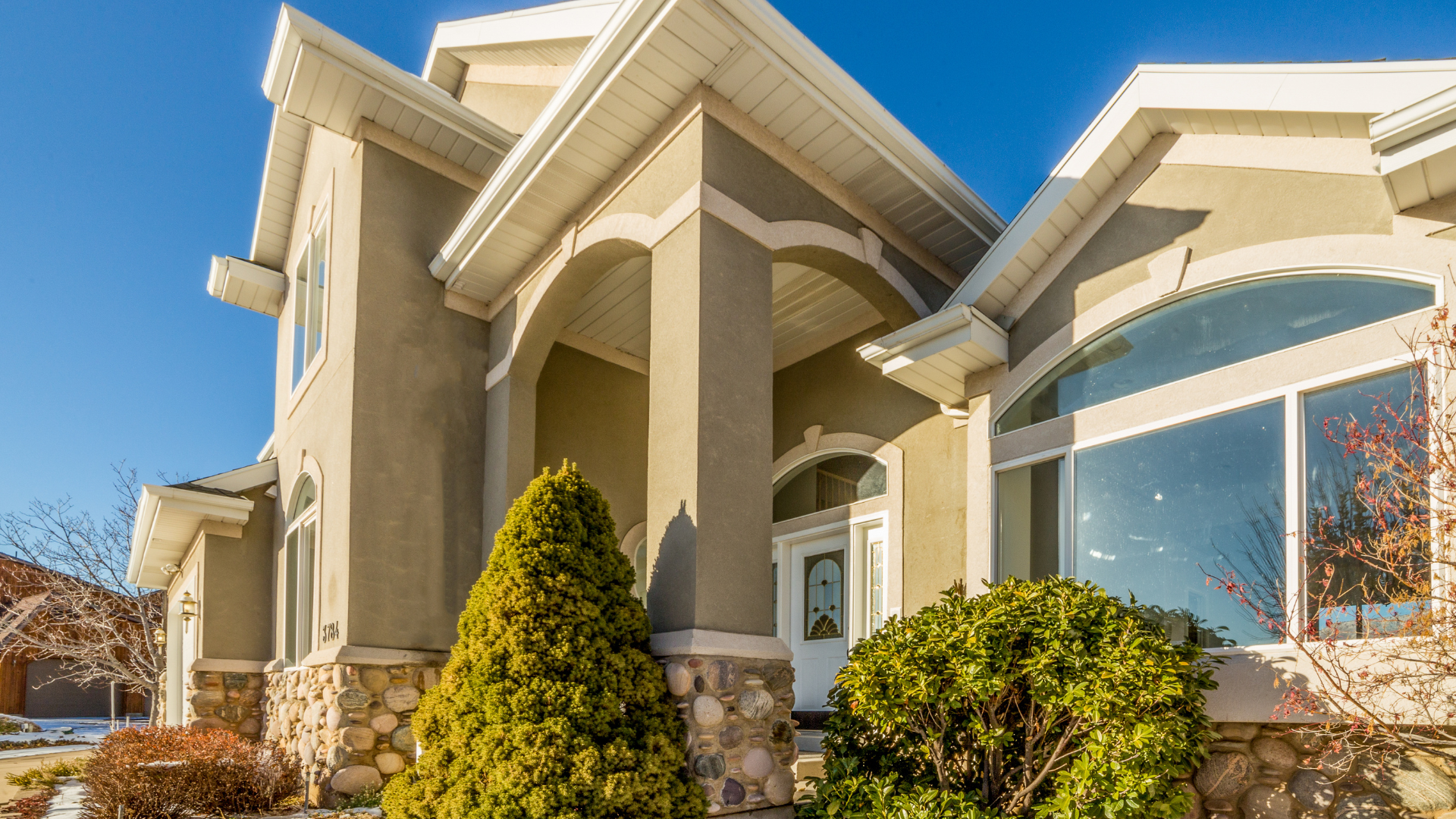 A large house with a lot of windows and trees in front of it.