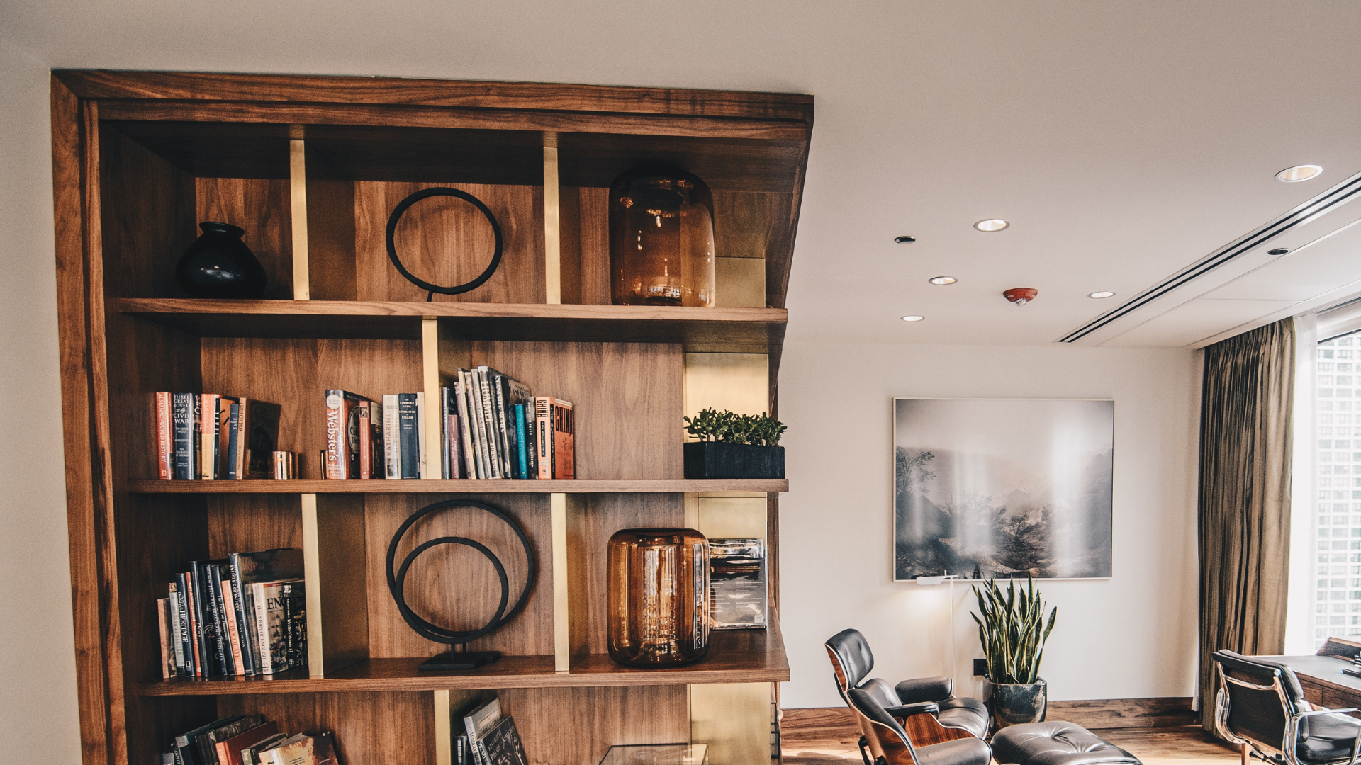 A living room with a wooden bookshelf filled with books.
